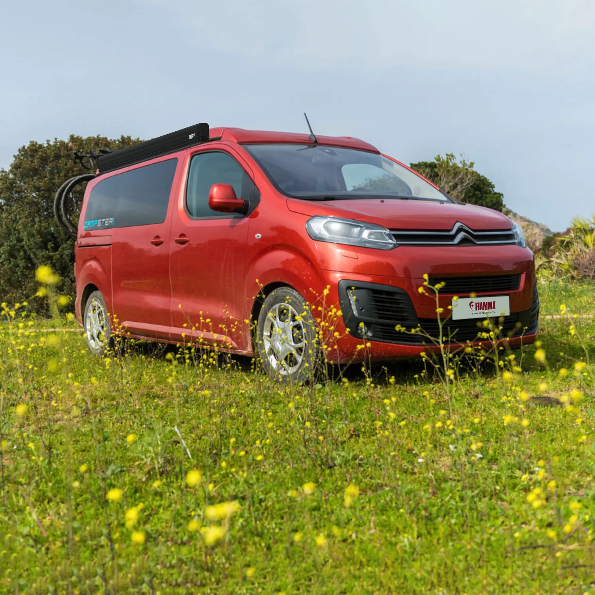 Schwarze Fiamma F45s Stellantis Markise, geschlossen am Dach eines roten Citroën-Kastenwagens montiert