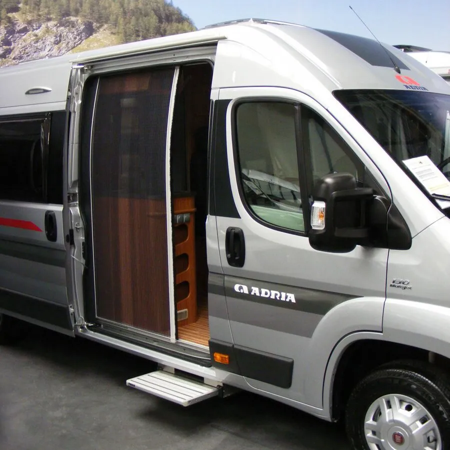 Offene Schiebetür eines silbernen Mercedes-Benz Sprinter mit eingesetzter Plissee-Fliegenschutztür und Trittstufe