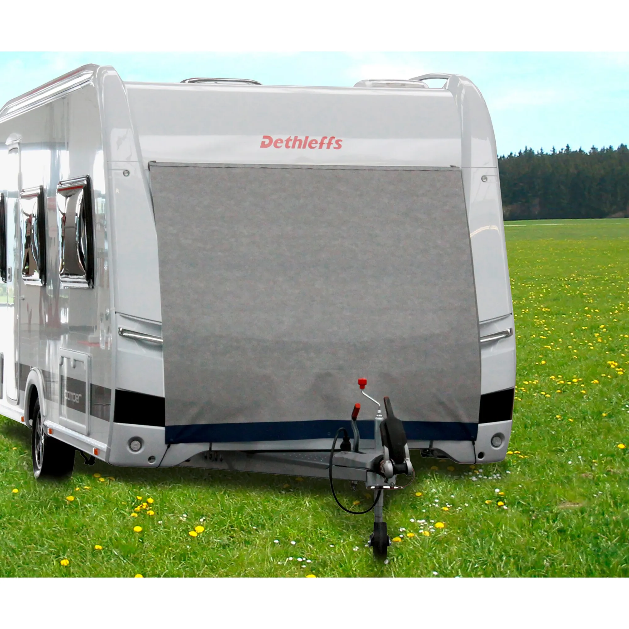 Graue Caravan-Bugschutzplane Supra an der Front eines weißen Dethleffs-Wohnwagens auf einer Wiese, erhältlich in 140 und 160 cm