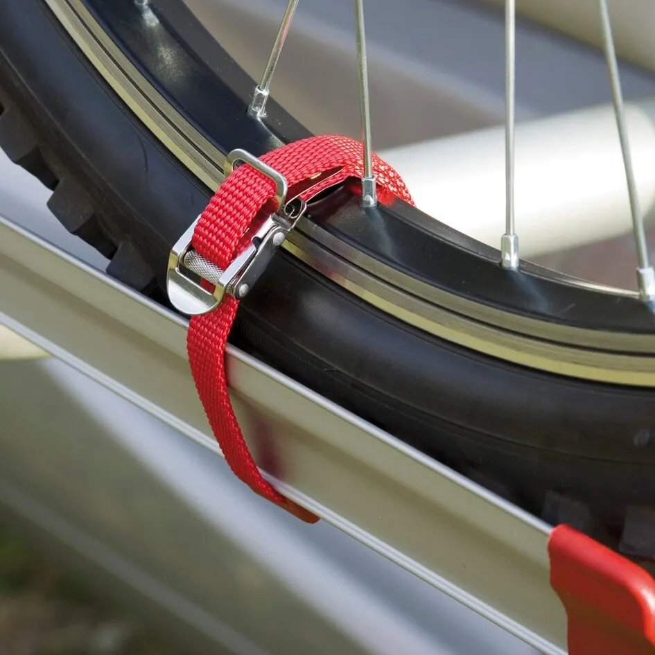 Roter Sicherheitsriemen mit Metallschnalle an einer Fahrradspeiche und Felge befestigt, Detailaufnahme am Fahrradreifen