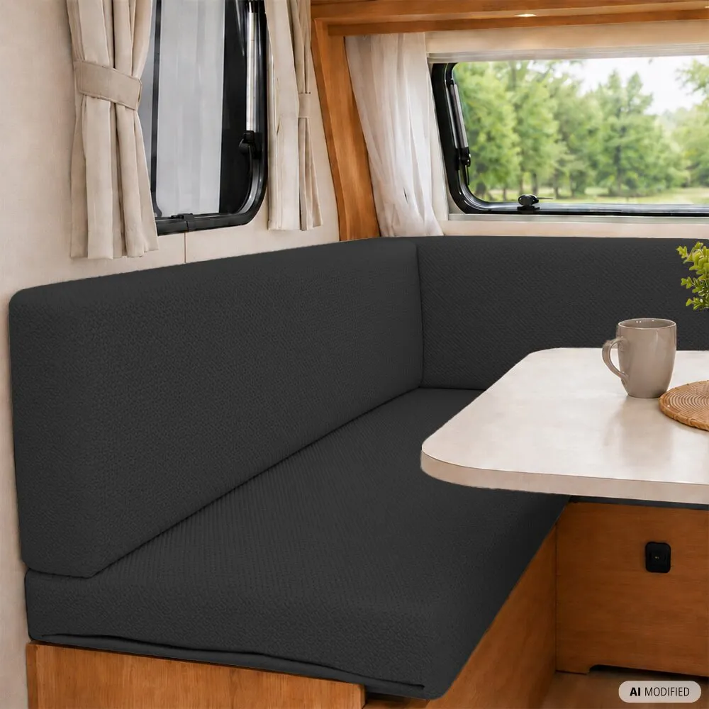 Schwarzer Polsterschlauch FlexiCover auf Sitzpolstern einer Wohnmobil-Sitzgruppe mit Tisch, Fenstern und Vorhängen