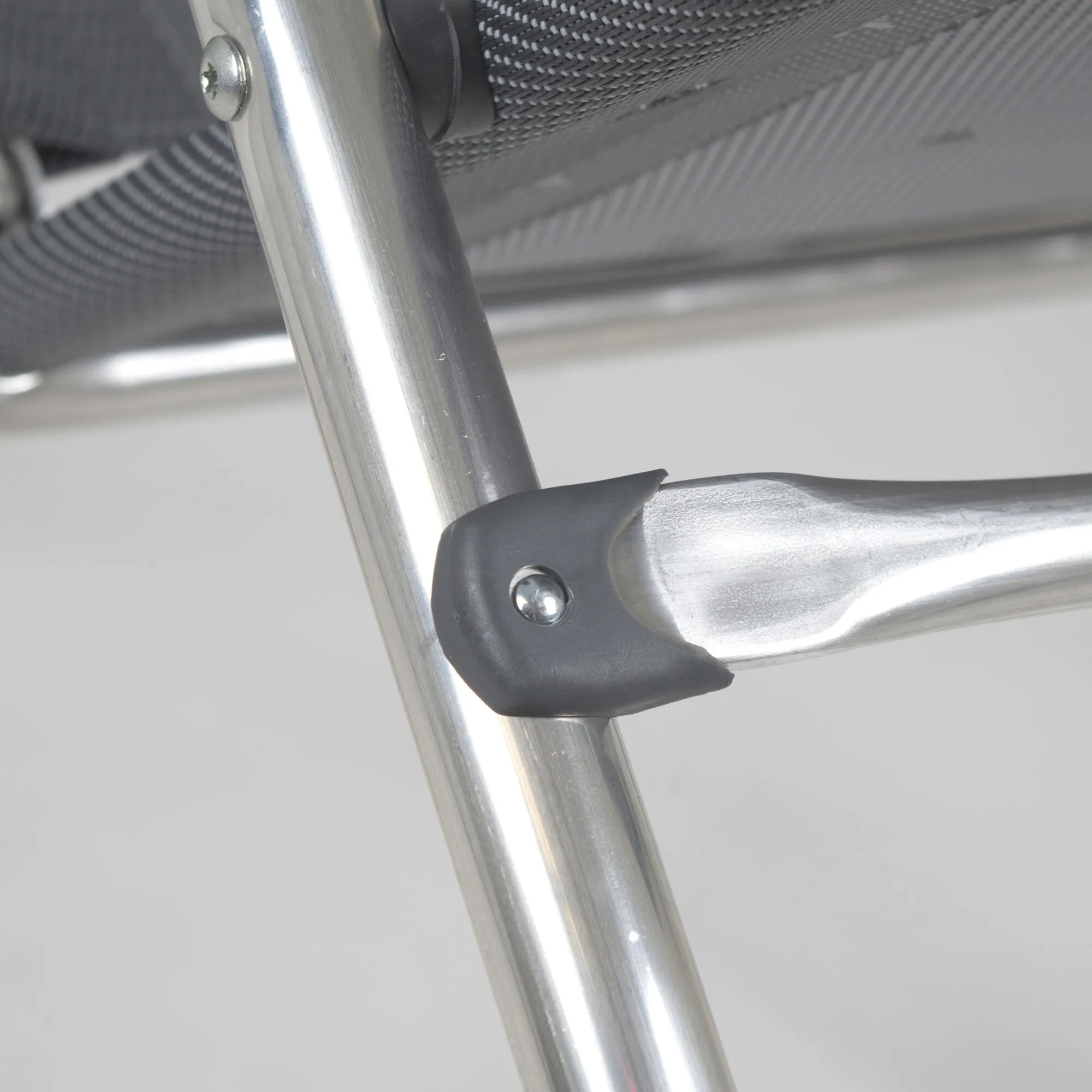 Detailaufnahme des Campingstuhls AL/213 Classic mit silbernem Aluminiumgestell, schwarzer Kunststoffverbindung und grauem Netzgewebe