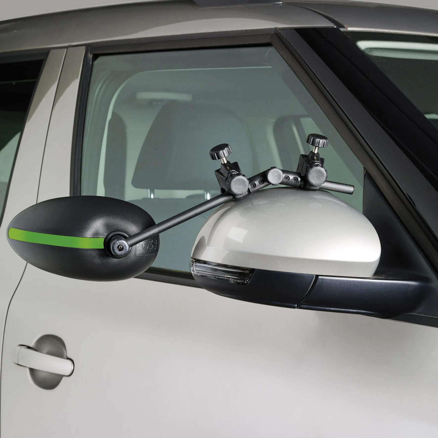 Schwarzer Caravanspiegel Speed Fix Mirror mit grüner Zierleiste, an einem weißen Autoaußenspiegel befestigt