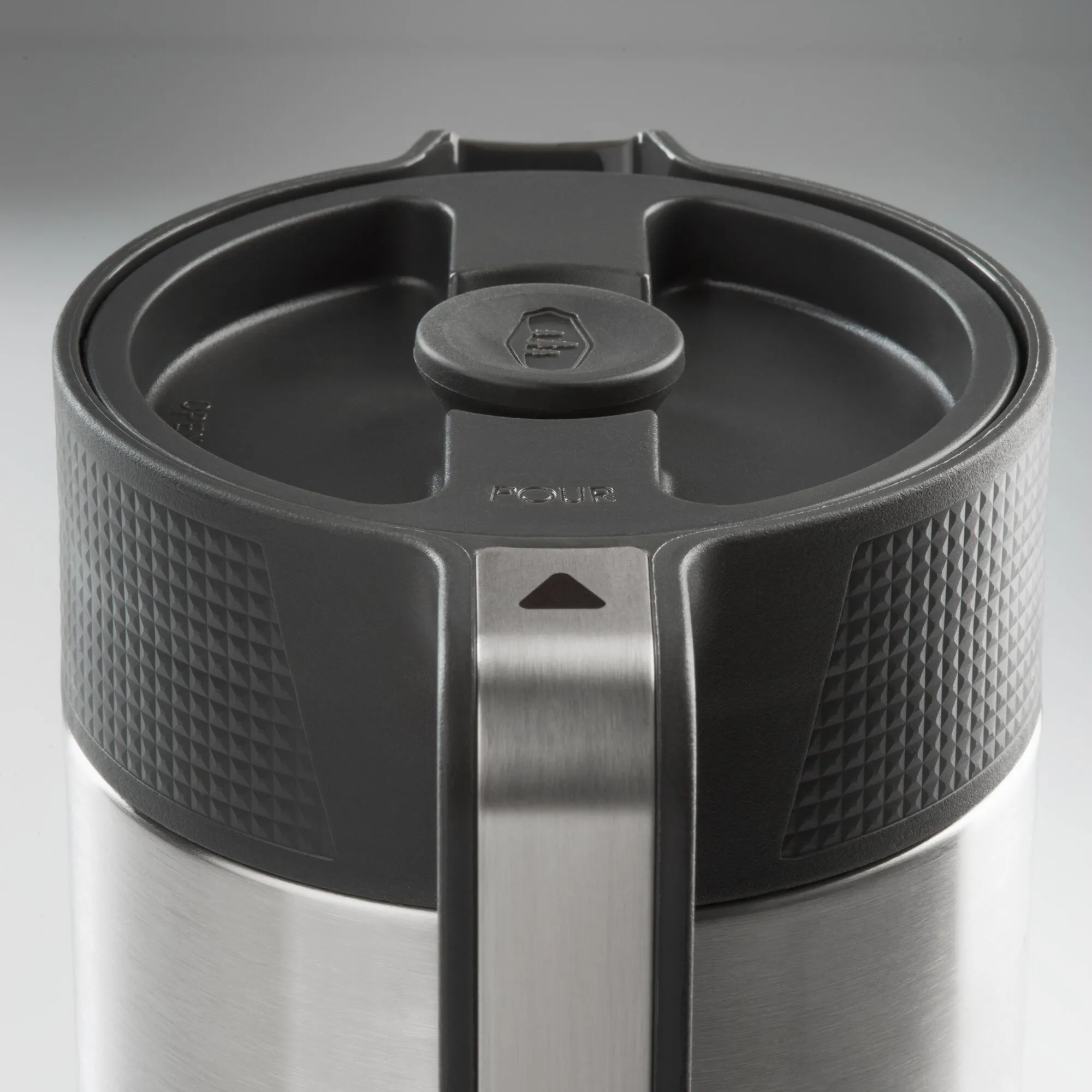 Detailaufnahme des schwarzen Kaffeebereiters JavaPress mit strukturiertem Gehäuse, Edelstahlfläche und offenem Deckel mit Pressstempel