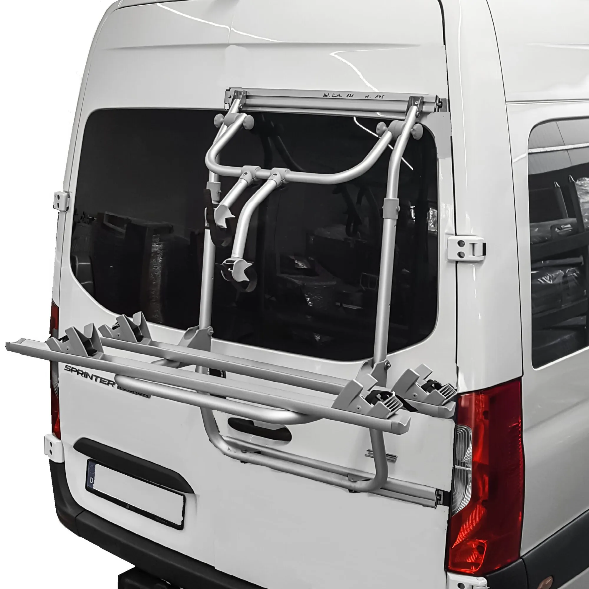 Silberner Fahrrad-Hecktürträger an der geöffneten Hecktür eines weißen Mercedes-Benz Sprinter für mehrere Fahrräder