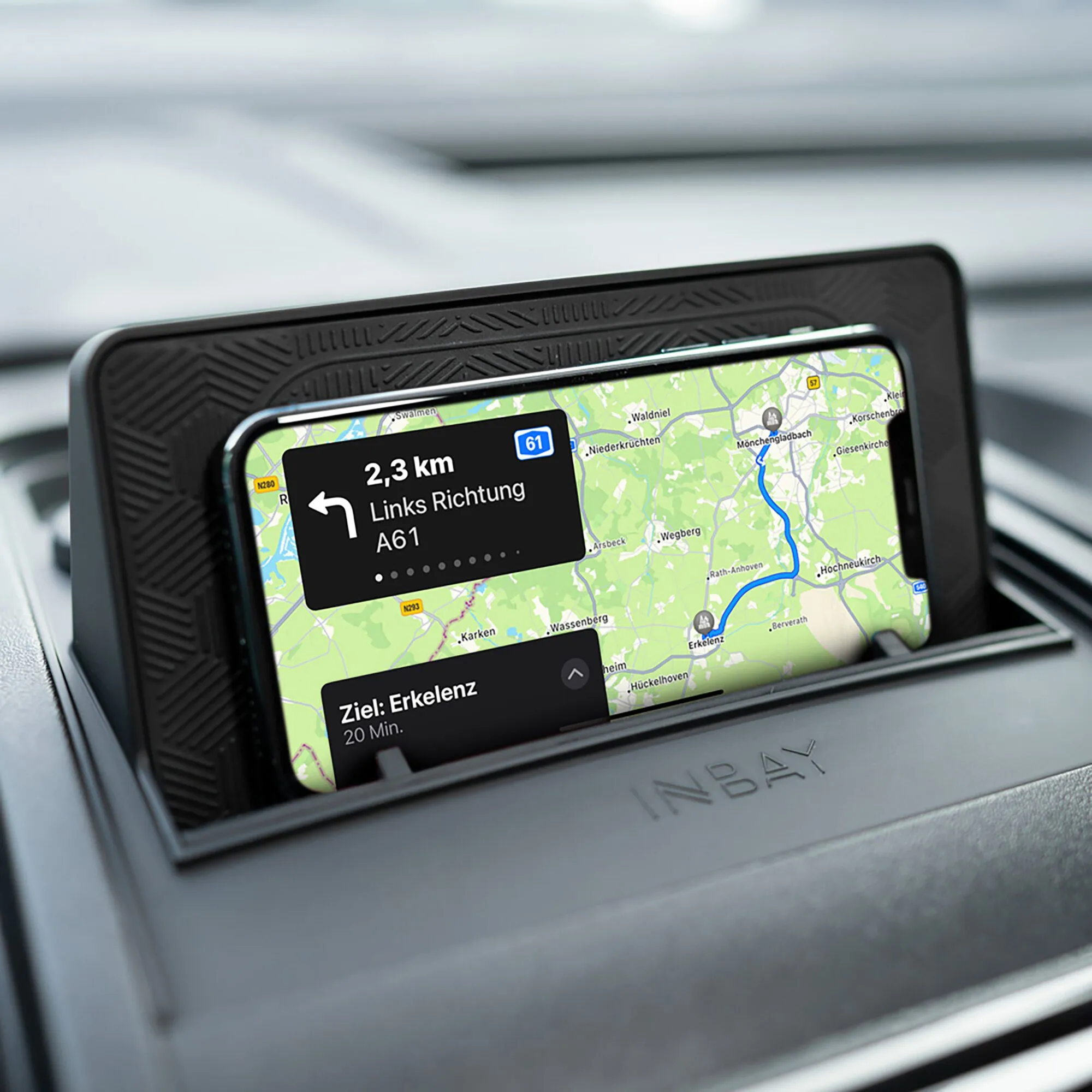 Schwarze INBAY Qi-Ladestation im Armaturenbrett eines Fiat Ducato mit eingelegtem Smartphone und sichtbarer Navigationskarte