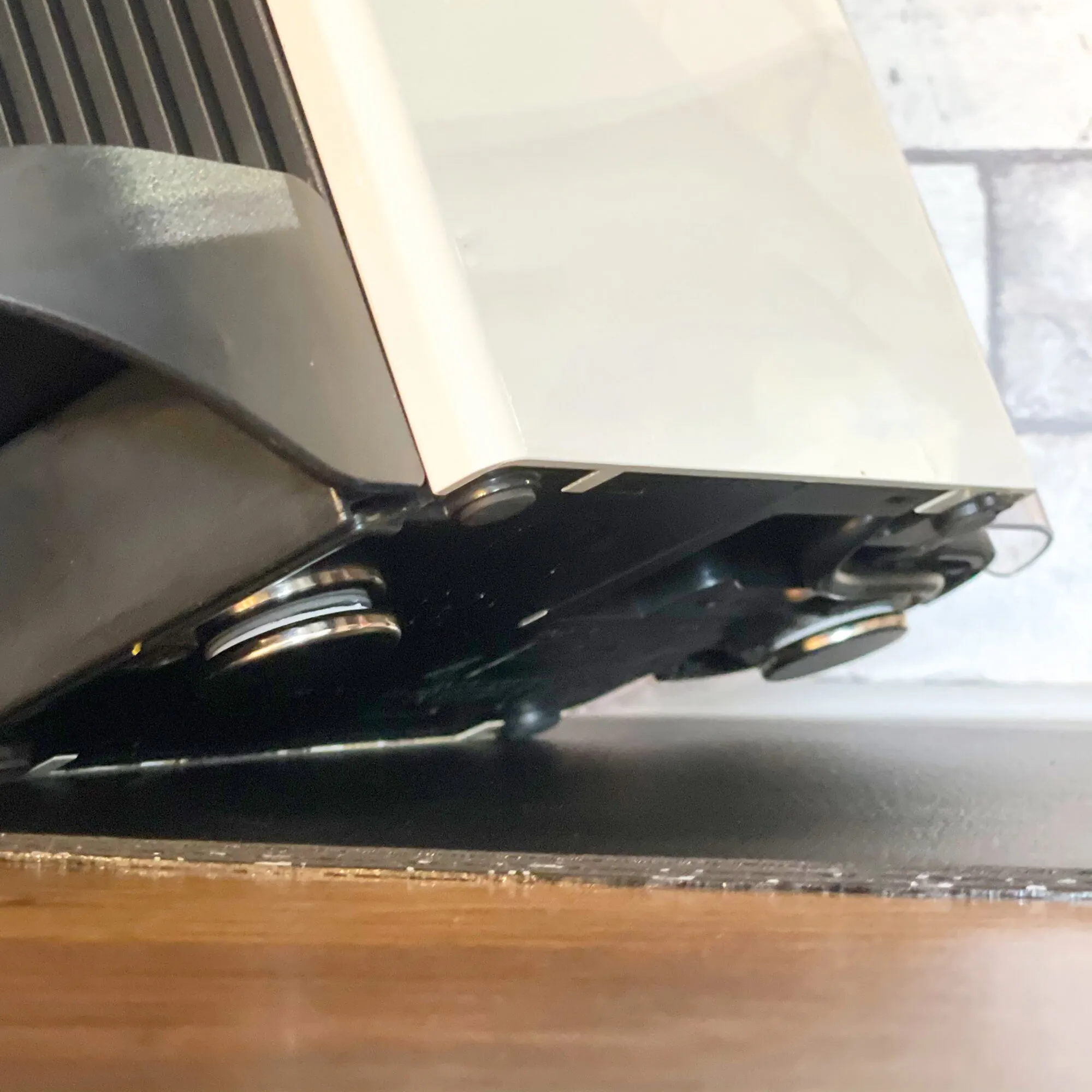 Detailaufnahme mehrerer runder, silbern glänzender Power-Magnete unter einer weißen Platte an einer schwarzen Halterung