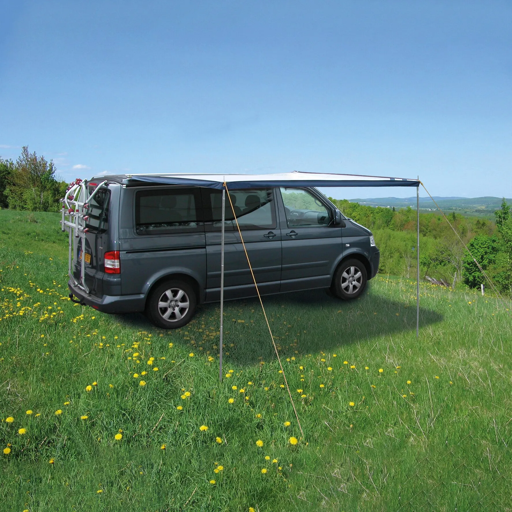 Dunkelblaues Sonnendach Fjord mit 260 cm Breite an einem grauen Campingbus auf einer blühenden Wiese gespannt