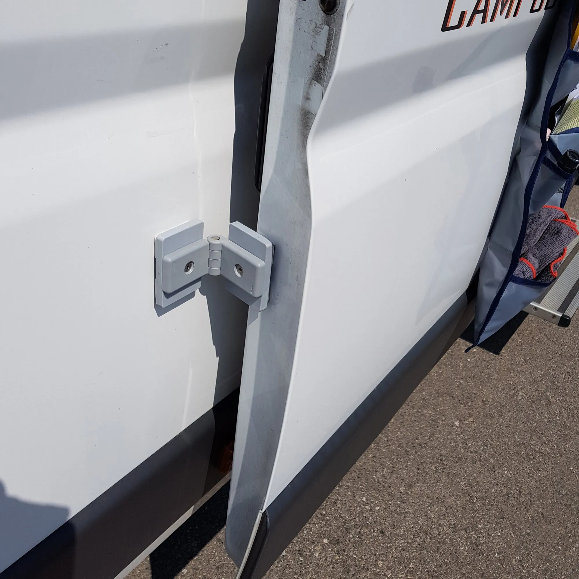 Weißes Magnet-Set Classic an den geöffneten Türen eines Fahrzeugs montiert, mit sichtbaren Befestigungsschrauben und Scharnierverbindung