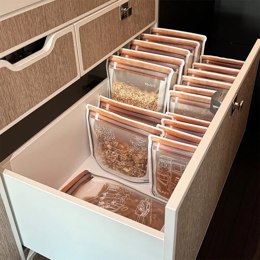 Innenansicht einer Schublade mit vielen transparenten Aufbewahrungsbeuteln, braune Reißverschlüsse mit Holzoptik; 32-tlg. Camping-Set