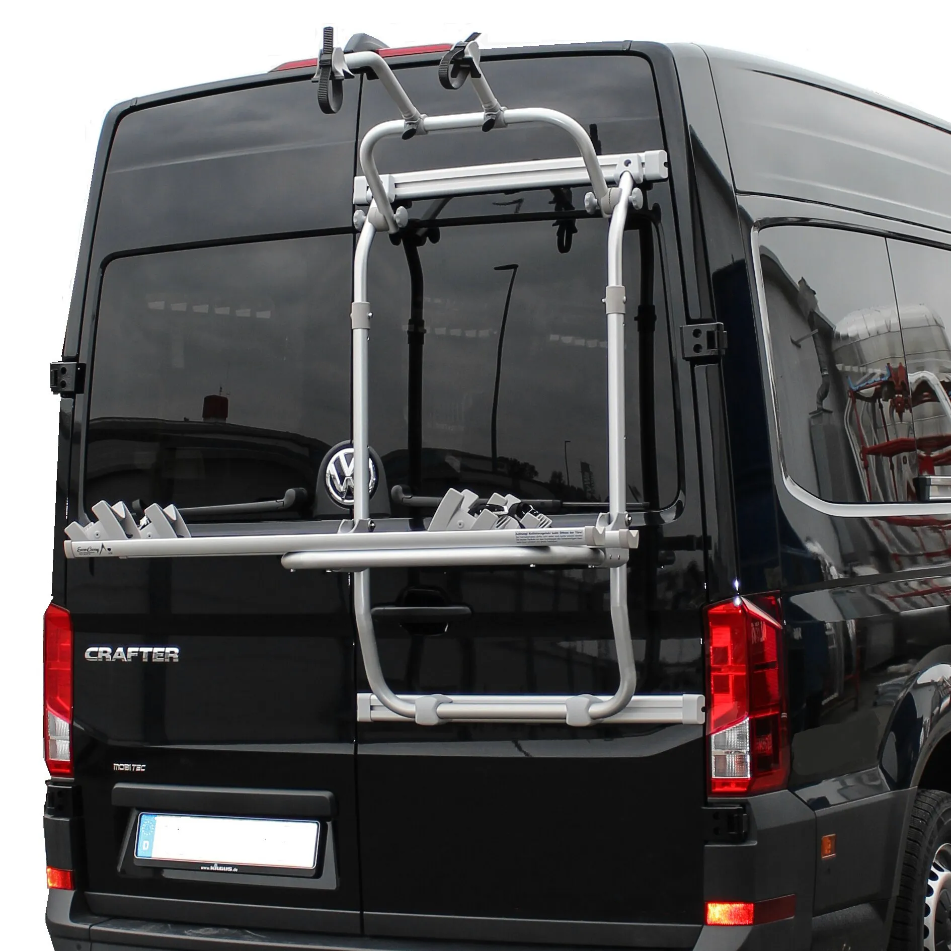 Silberner Hecktürträger für Fahrräder an den Hecktüren eines schwarzen VW Crafter der zweiten Generation montiert