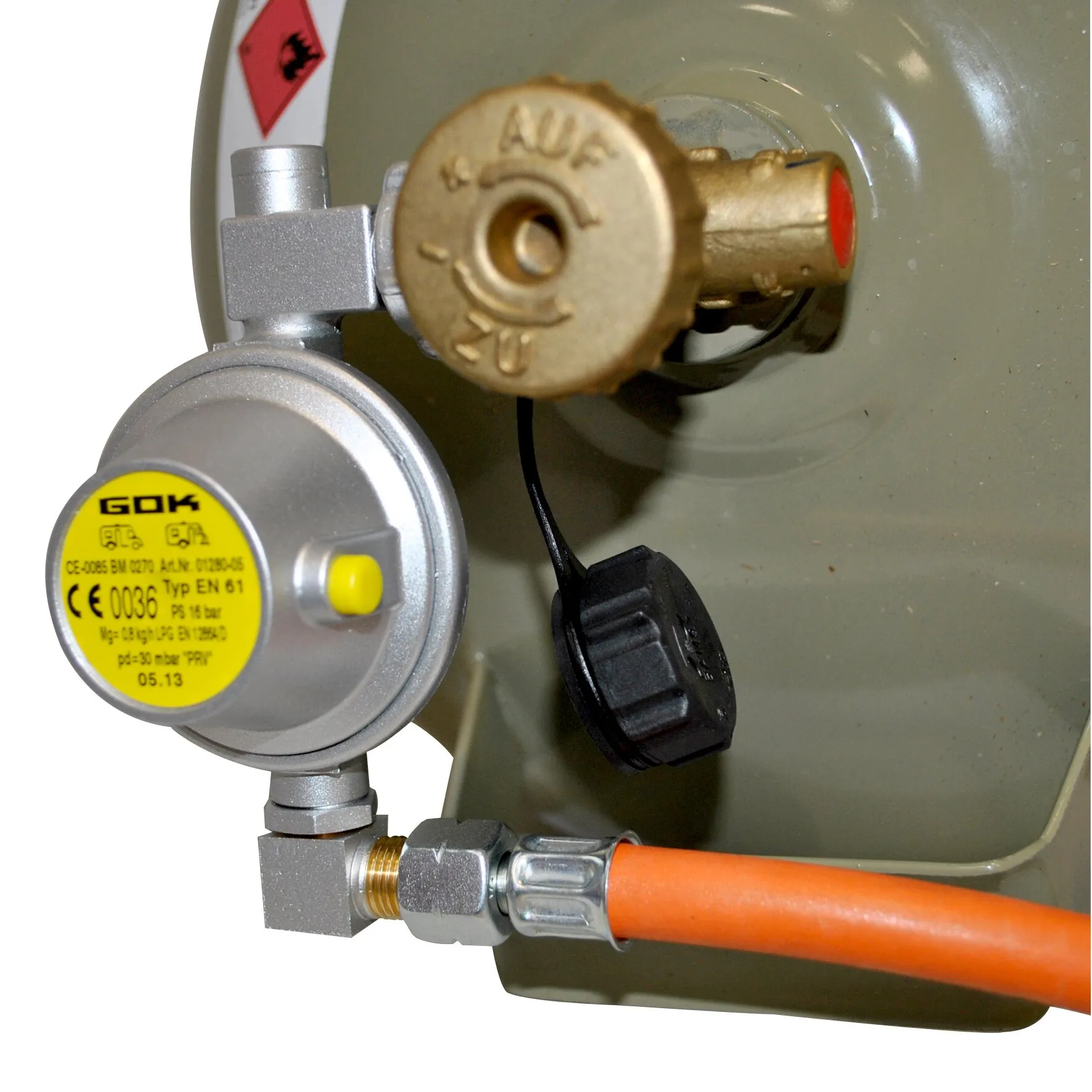 Niederdruckregler in U-Form mit rundem Manometer, Messinganschluss und orangefarbenem Gasschlauch an einer Gasflasche