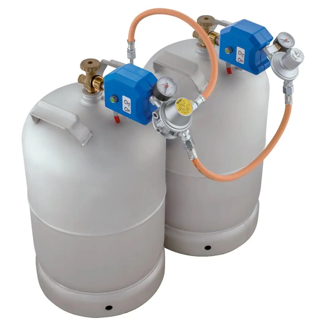 Zwei graue Gasflaschen nebeneinander, beide blauen Druckregler mit Manometern, orange Verbindungs-Schlauch und Metallventile sichtbar