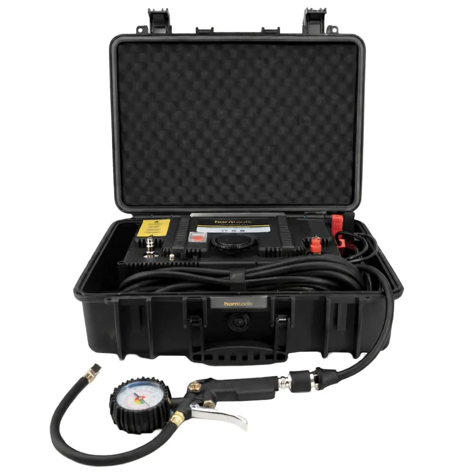Geöffnetes schwarzes Hartschalenkoffer mit Schaumstoffeinlage und tragbares Kompressor-Kit, inklusive Manometer, Schlauch und Reifen-Inflator