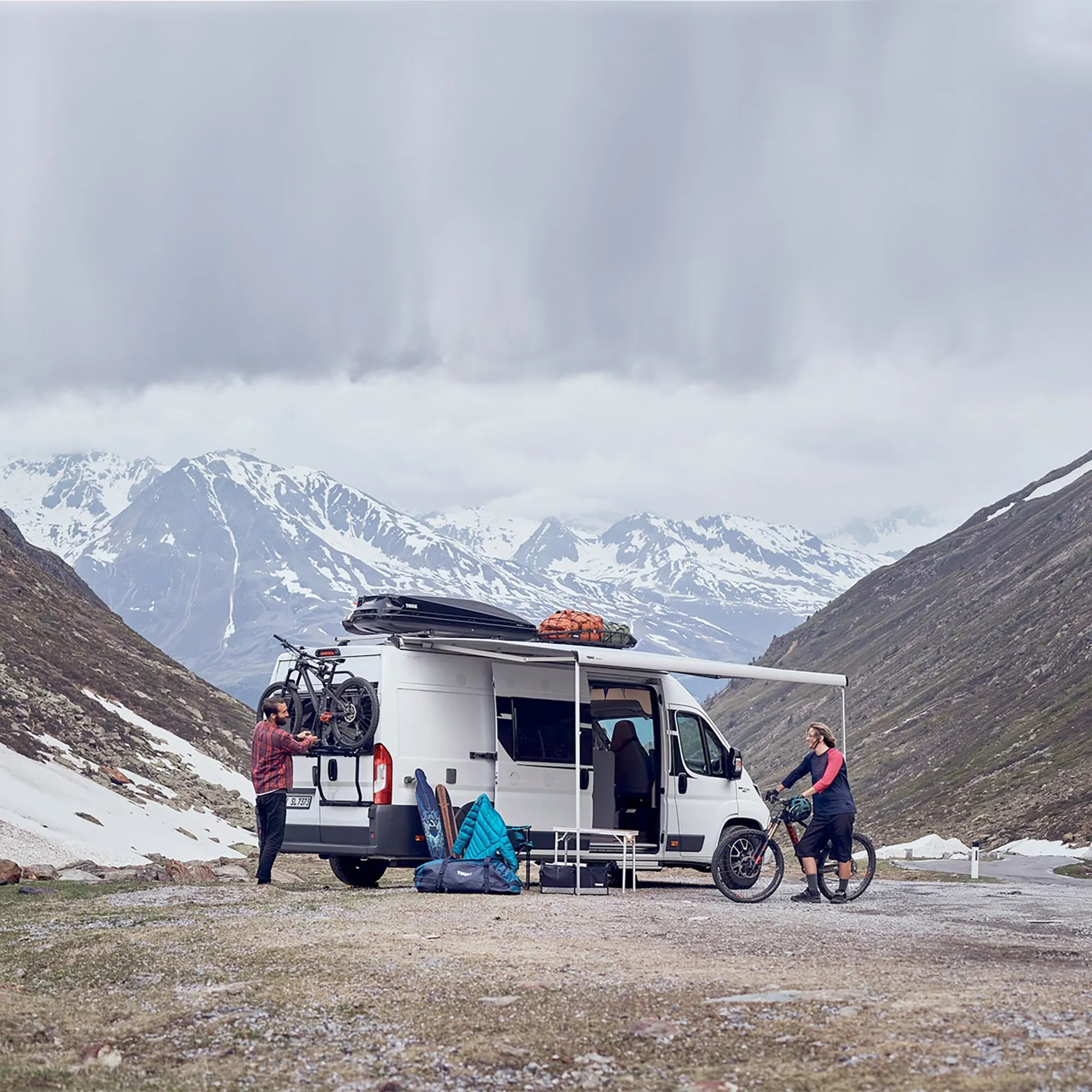 Weißer Fiat Ducato mit schwarzem Thule Elite Van XT Fahrradträger und zwei Fahrrädern vor verschneiter Bergkulisse