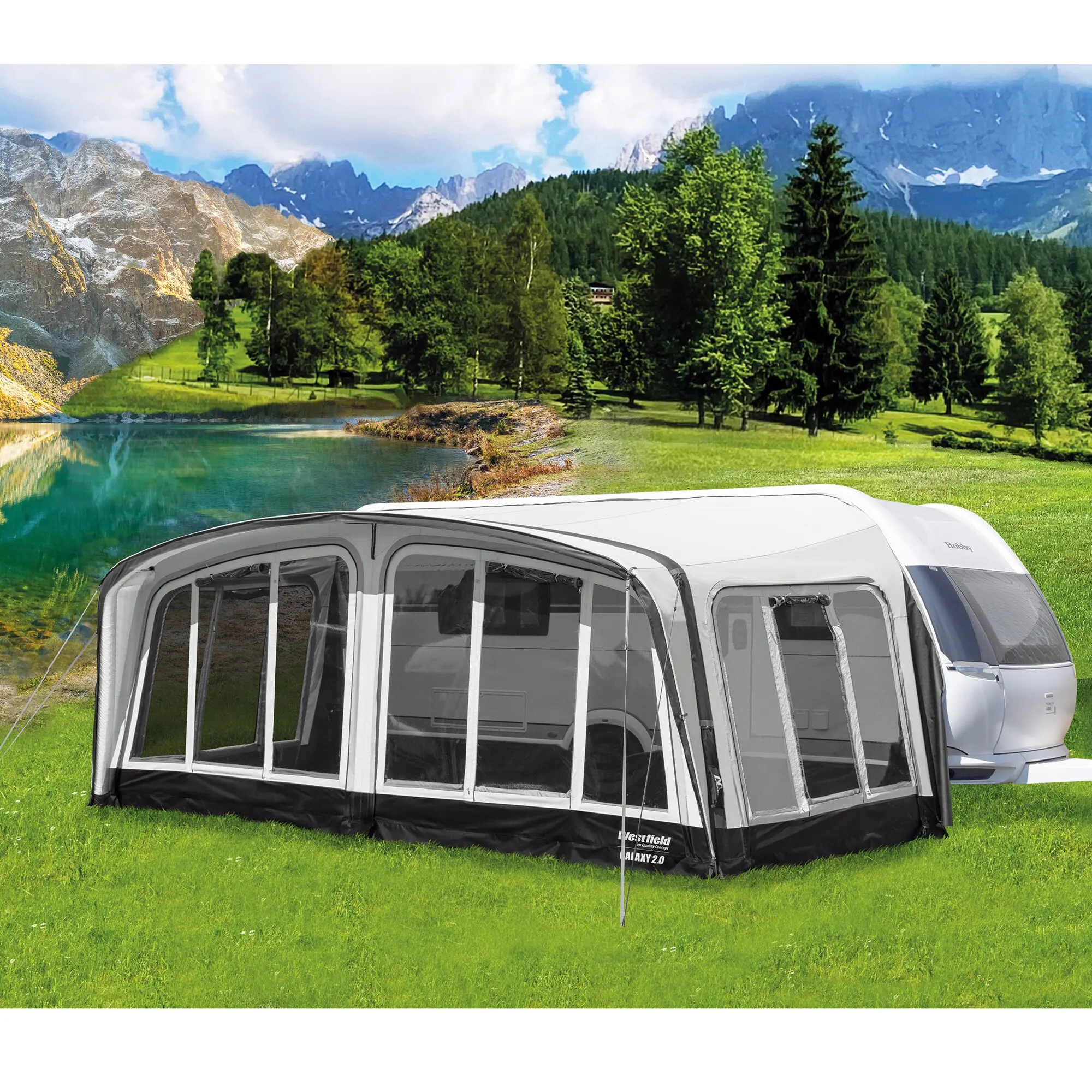 Reisevorzelt Galaxy 2 in Grau an Wohnwagen angebaut, seitliche Fenster, schwarzer Bodenabschluss, grüne Wiese und Bergkulisse