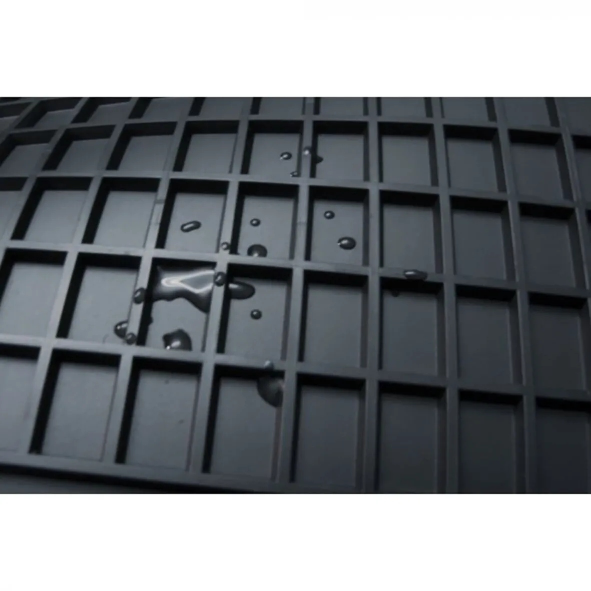 Detailaufnahme einer schwarzen Gummimatte mit quadratischem Wabenprofil und aufgefangenen Wassertropfen, passend für VW T5/T6 2-Sitzer