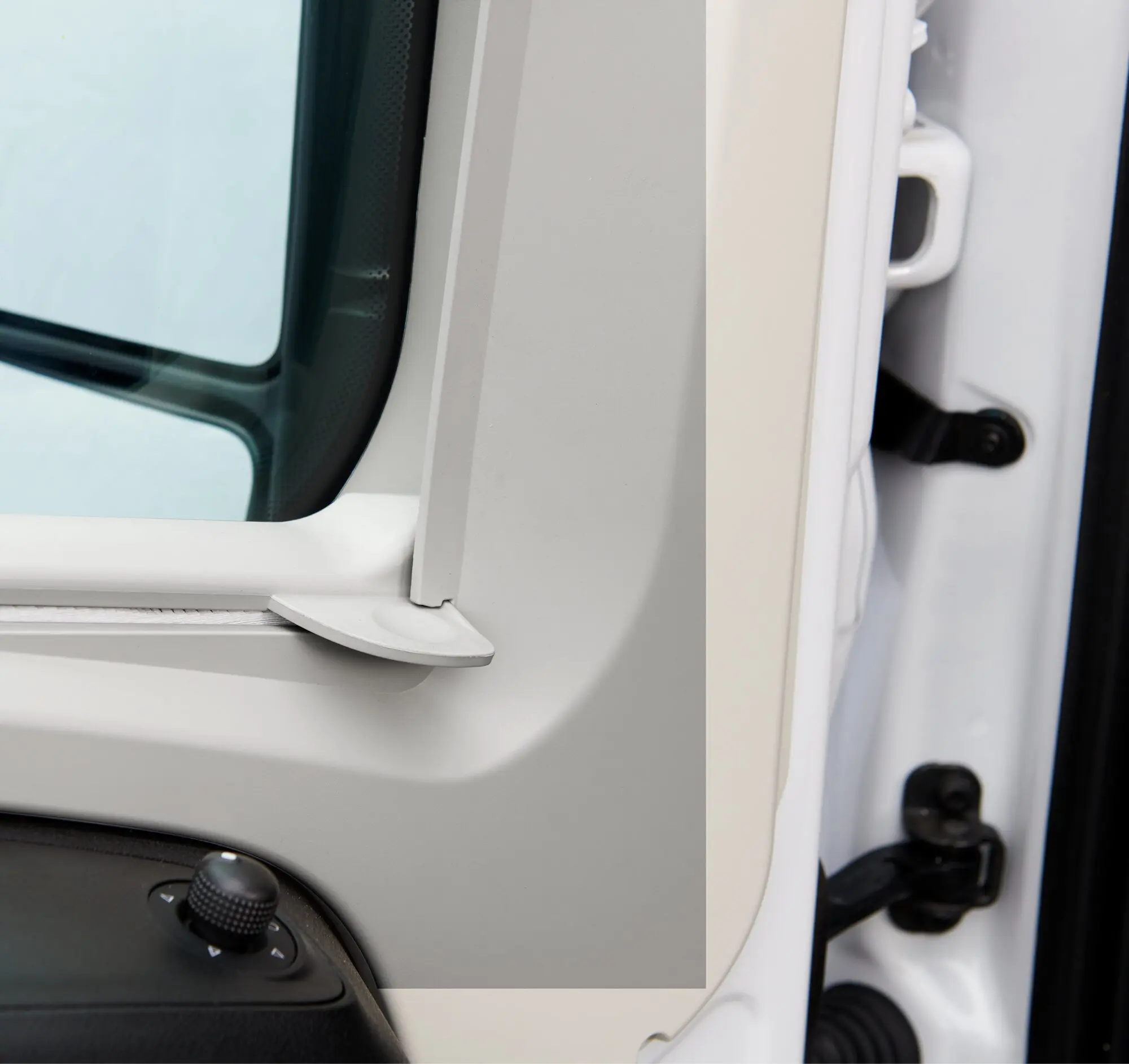 Detailaufnahme der SP 310 Seitenscheibenverdunkelung an einem Freizeitfahrzeug, grauer Verdunkelungsrahmen neben dem Fenster