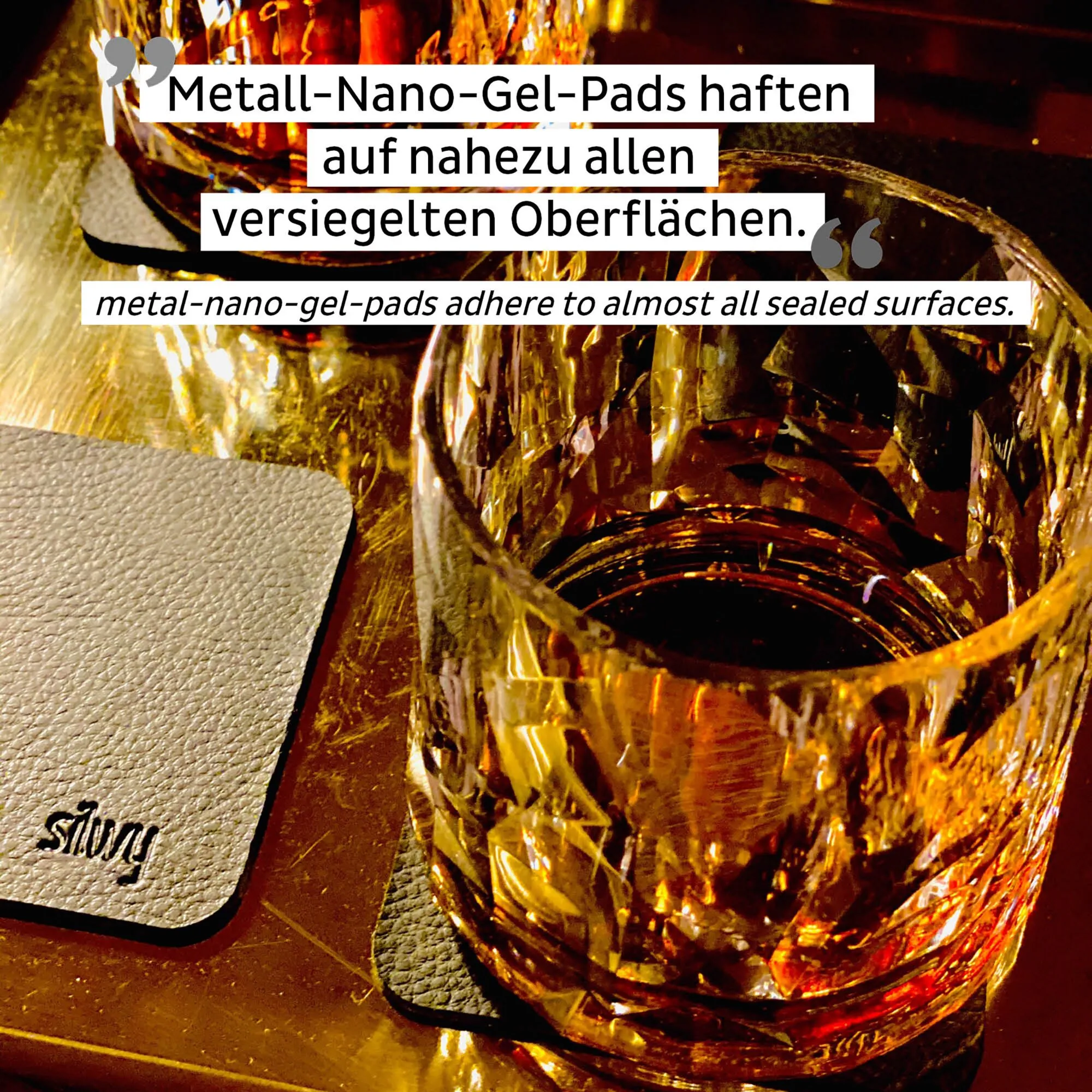 Transparentes Magnet-Kunststoffglas für Whisky mit bernsteinfarbenem Getränk auf dunkler Unterlage; Hinweis zu Metall-Nano-Gel-Pads