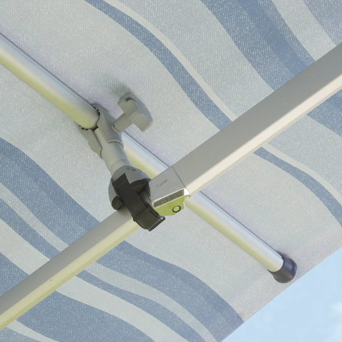 Detailaufnahme der Querstange Magicrafter 450 mit grauer Klemme an einem gestreiften Sonnenschirmgestänge