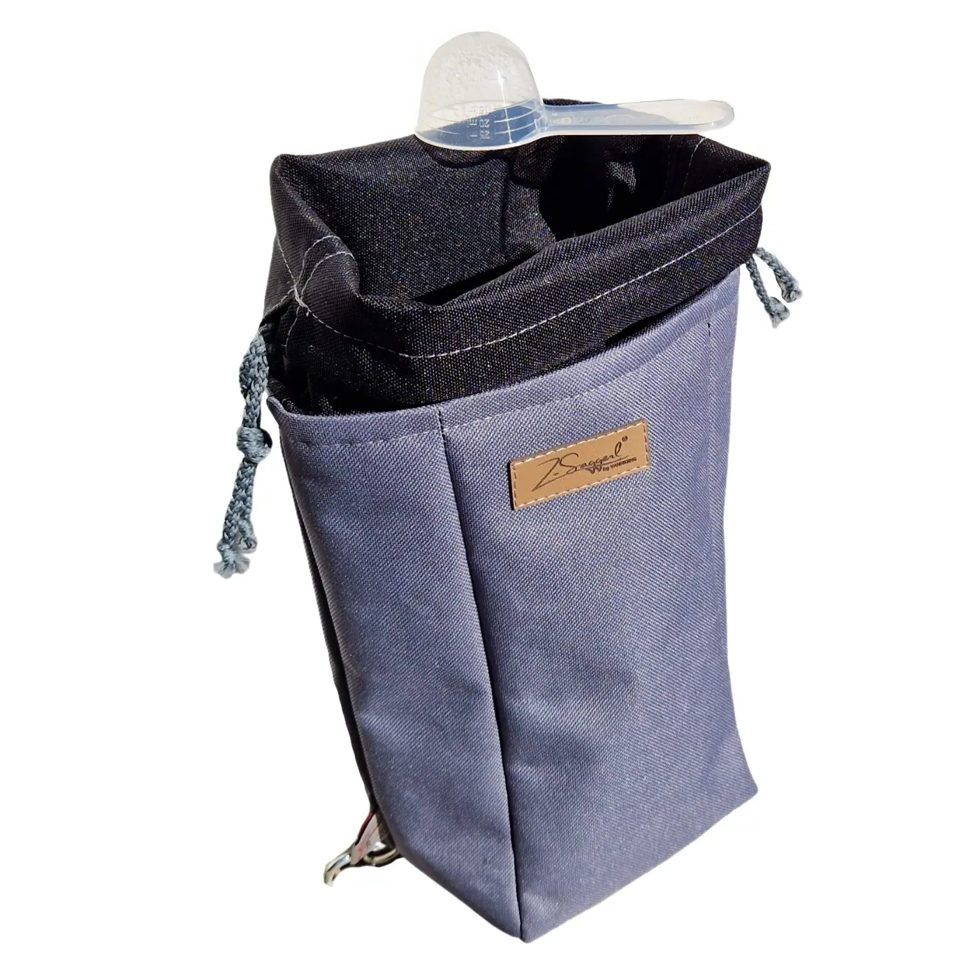 Stoffbeutel aus dunkelblauem Denim mit umgeschlagenem Rand, seitlichem Kordelzug und Leder-Label; darauf liegt ein transparenter Messbecher