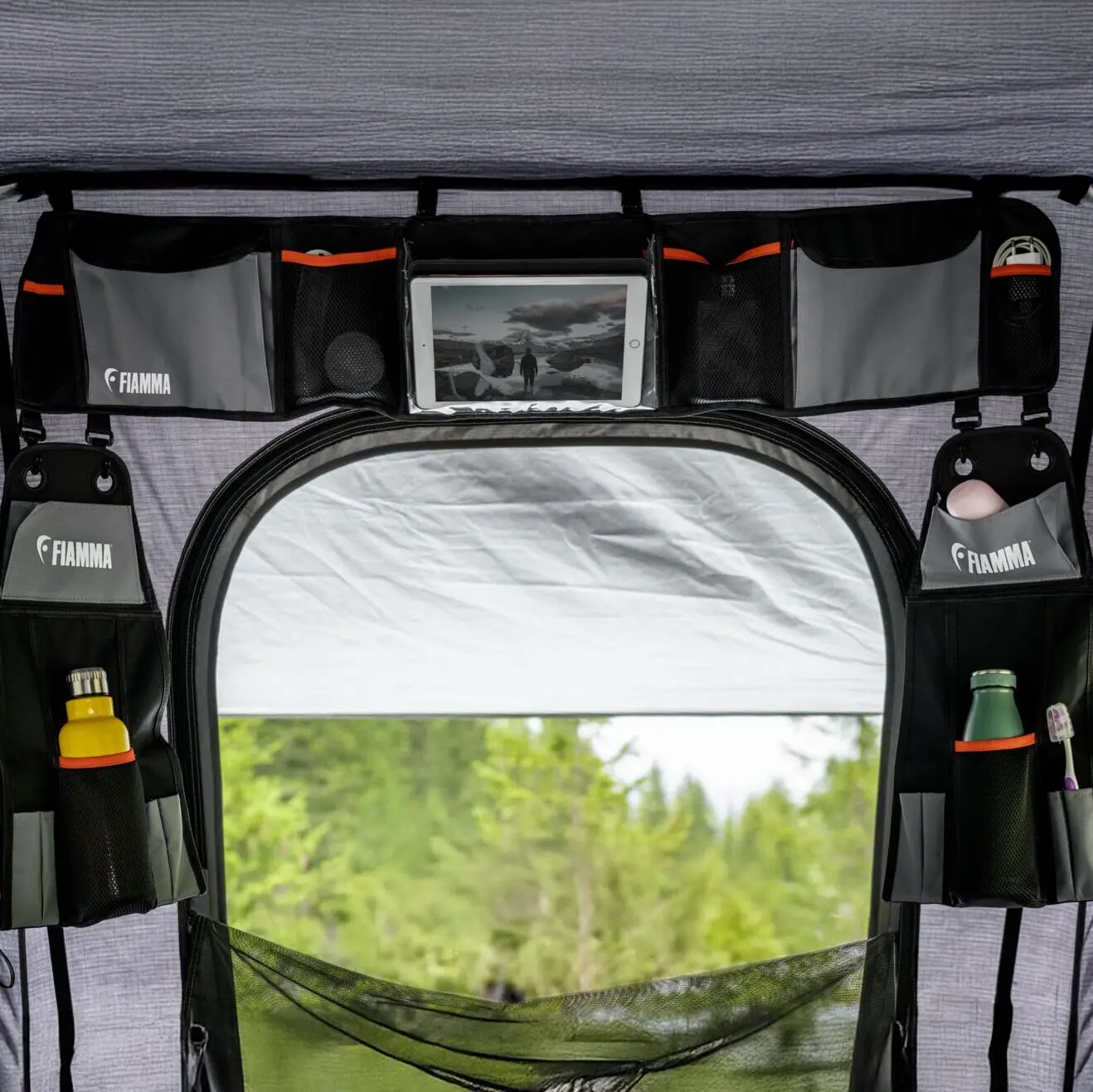 Innenraum eines Moonlight Tent Large mit Organizer über der Tür, Taschen, Tablet-Halter und Flaschenhalter, Blick nach draußen auf Wald
