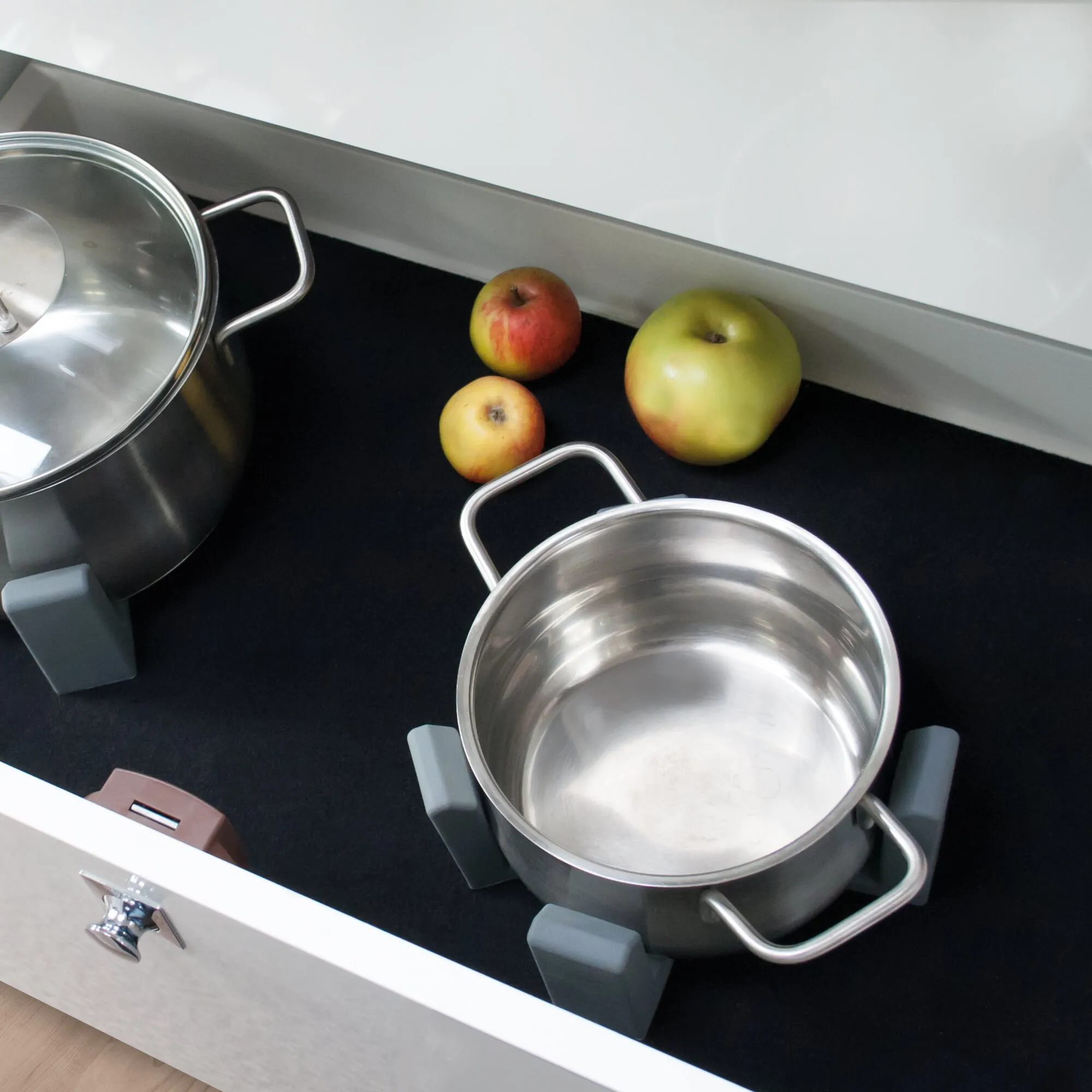 Vario System Modul III mit drei Edelstahltöpfen, grauen Griffen und Äpfeln auf schwarzer Ablage innerer Küchenschublade
