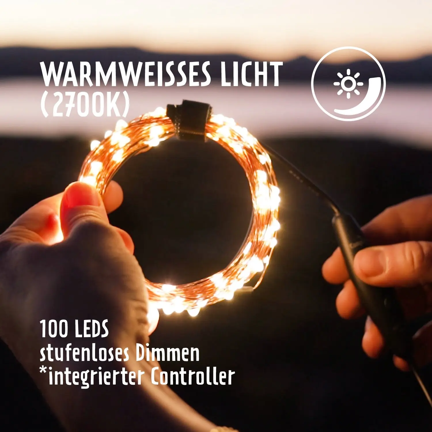 Hand hält eine geschlungene USB-Outdoor-Lichterkette mit 100 LEDs in warmweißem Licht, integriertem Controller; Hintergrund unscharf