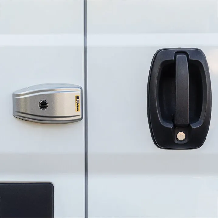 Silbergraues HEOSystem VAN Zusatzschloss neben schwarzem Türgriff an einer weißen Fiat-Ducato-Tür
