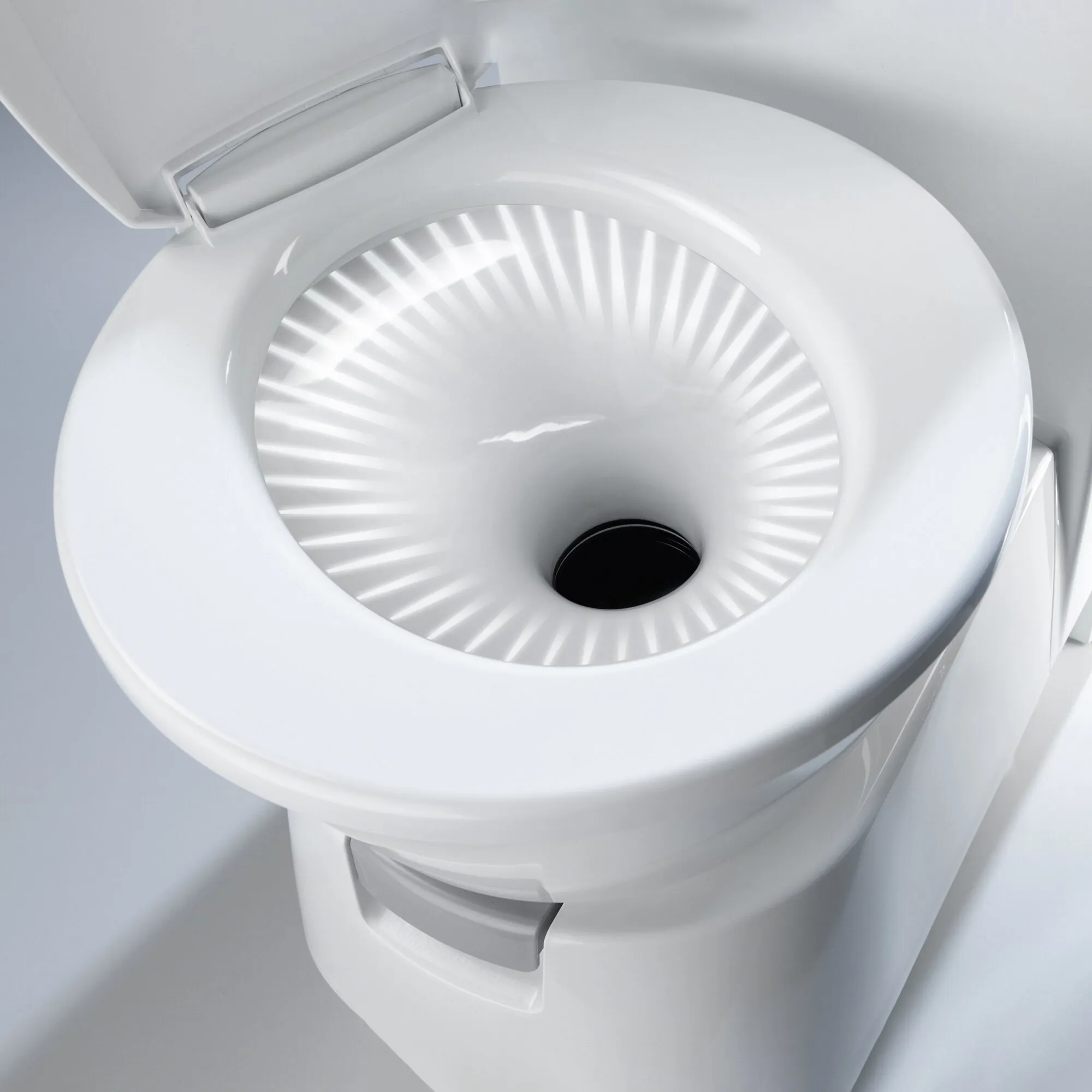 Weiße Cassettentoilette CT 4000 mit geöffnetem Deckel, geriffeltem Becken und sichtbarer Spülöffnung in Nahaufnahme