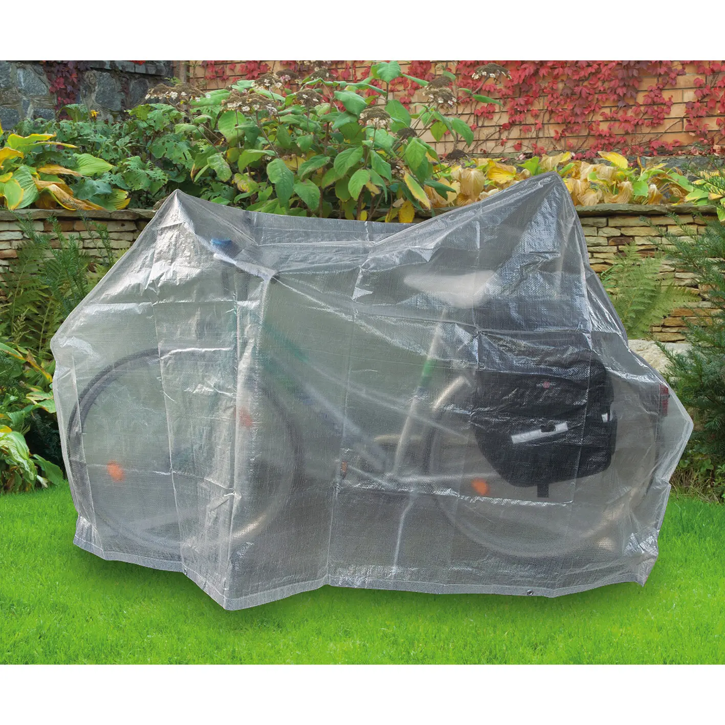 Transparente Fahrradschutzhülle über einem Fahrrad auf einer Rasenfläche im Garten mit sichtbaren Gepäcktaschen darunter
