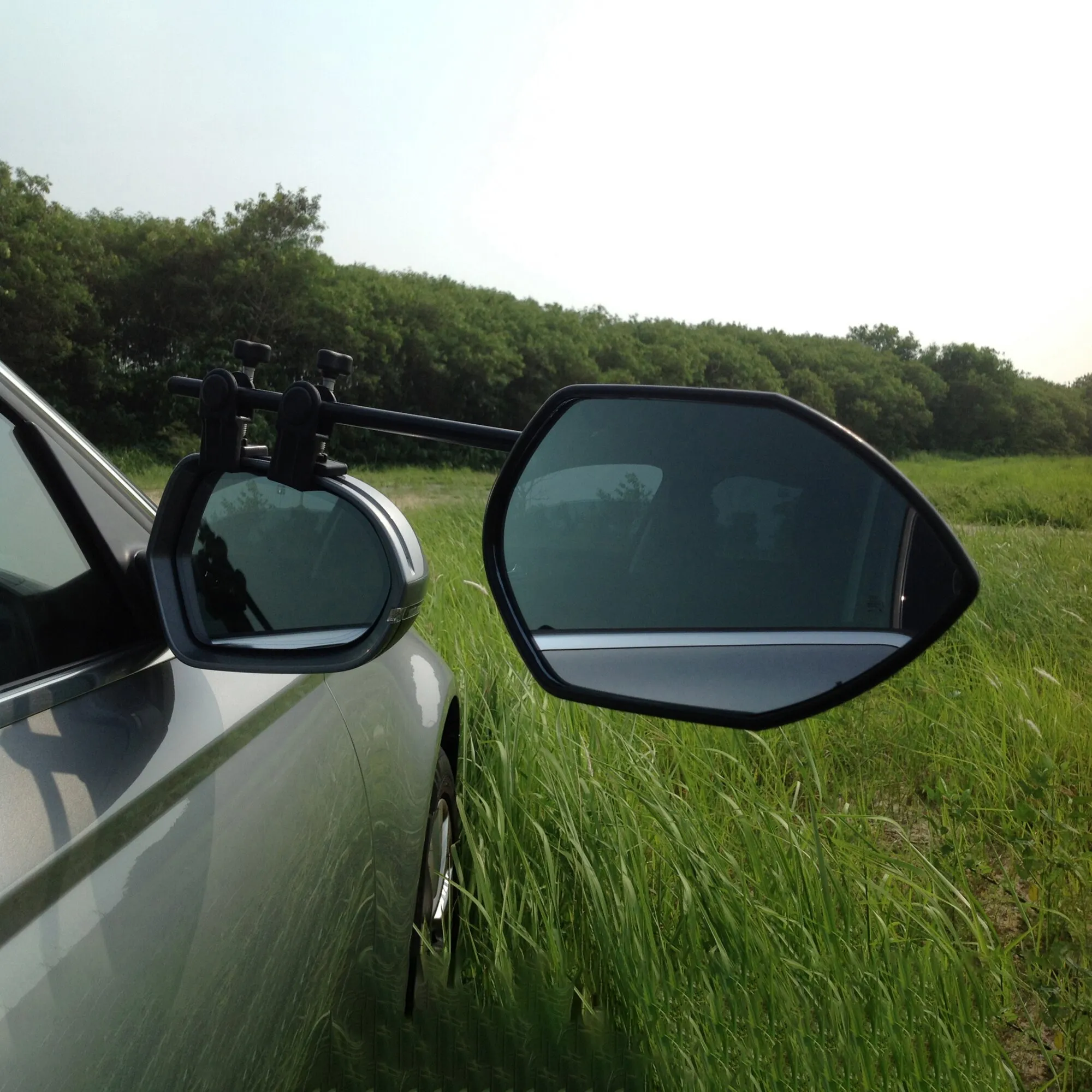 Caravanspiegel Falcon Mirror Twinpack an beiden Außenspiegeln eines silbernen Autos auf einer Wiese montiert