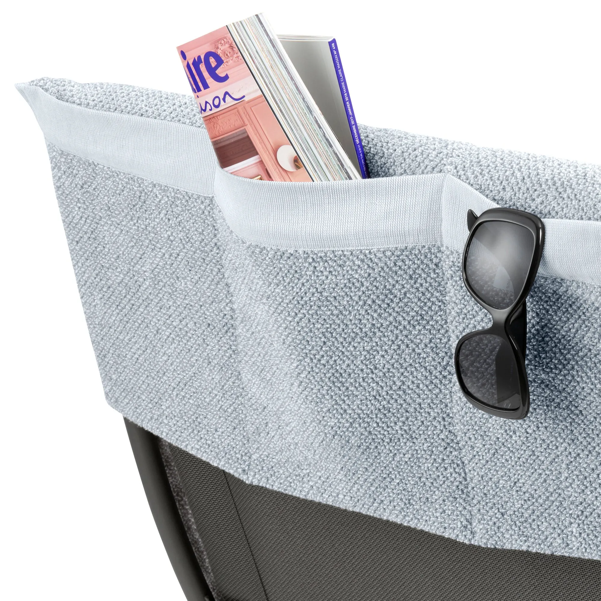 Hellgraue Frotteeauflage für einen Relaxsessel mit Seitentasche, Zeitschriften und Sonnenbrille in Detailansicht