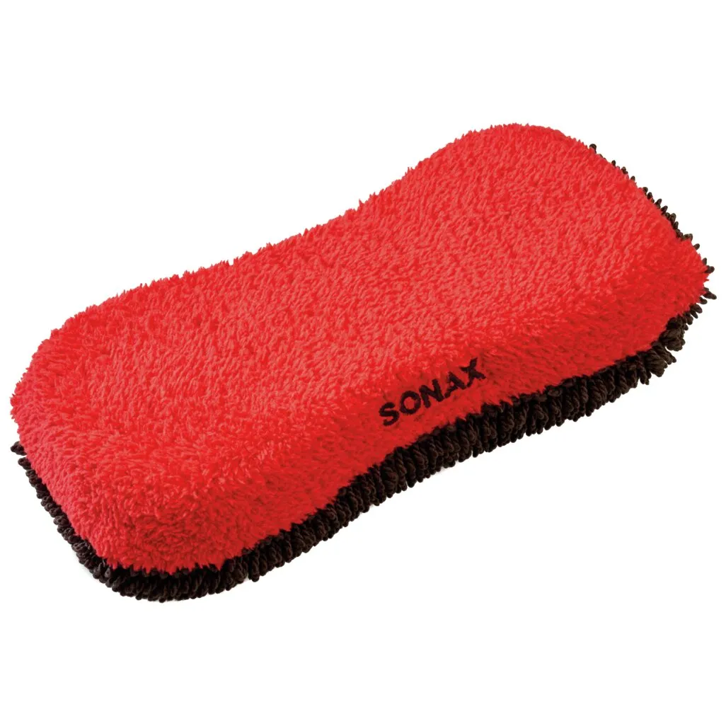 Roter Microfaser-Schwamm mit schwarzer Unterseite und abgerundeten Ecken, teilweise mit dem Aufdruck SONAX