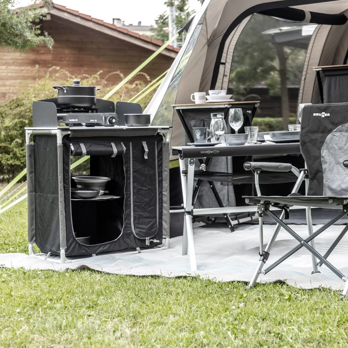 Schwarzer Kartuschen-Gaskocher Devil SD mit Topf und kleinem Kochtopf auf einem Campingtisch vor einem Zelt
