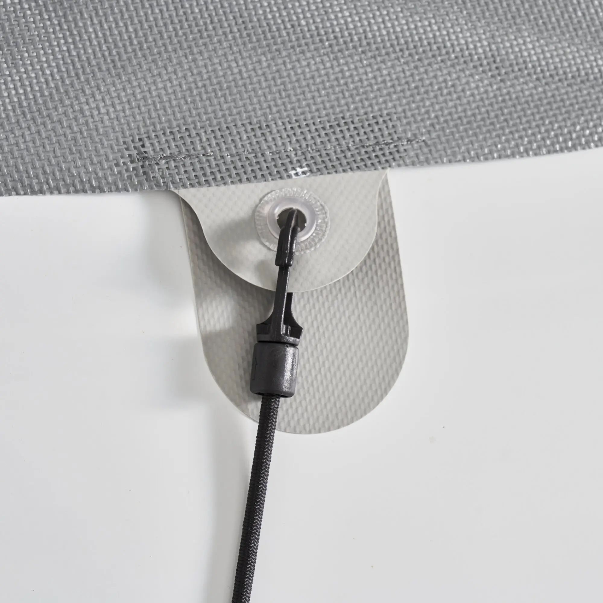 Detailaufnahme einer grauen gewebten Sonnenschutzmatte Screen, befestigt an einer metallischen Halterung mit schwarzem Kabel am Rand