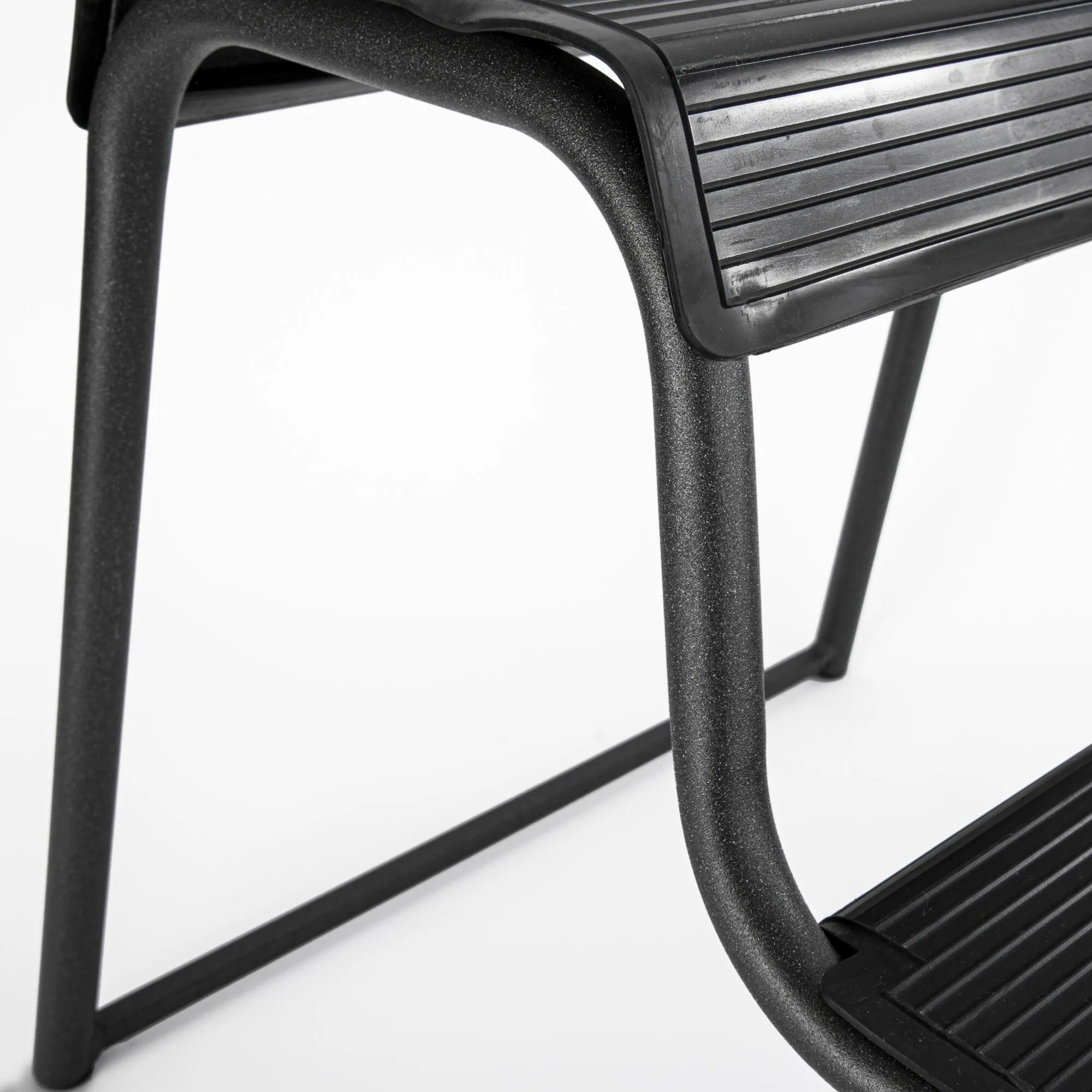 Detailaufnahme einer schwarzen Doppeltrittstufe mit zwei geriffelten Trittflächen und stabilem Metallrahmen