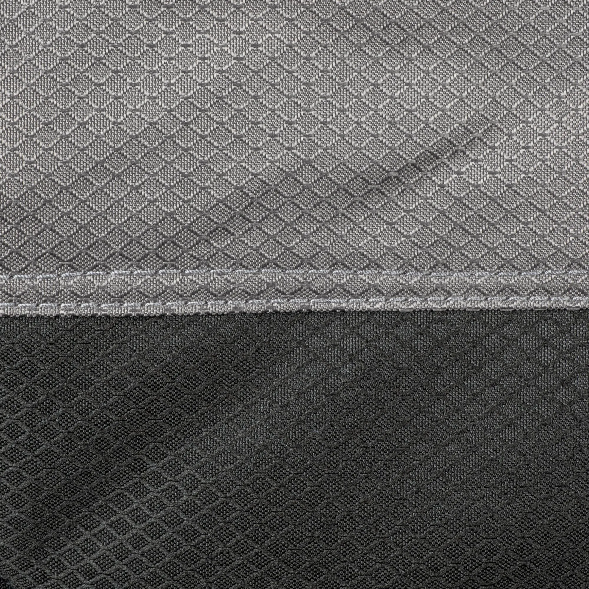 Nahaufnahme eines gemusterten Stoffes in Grautönen mit dichter Gewebe-Textur und wiederholtem Muster, sichtbare horizontale Naht am unteren Rand