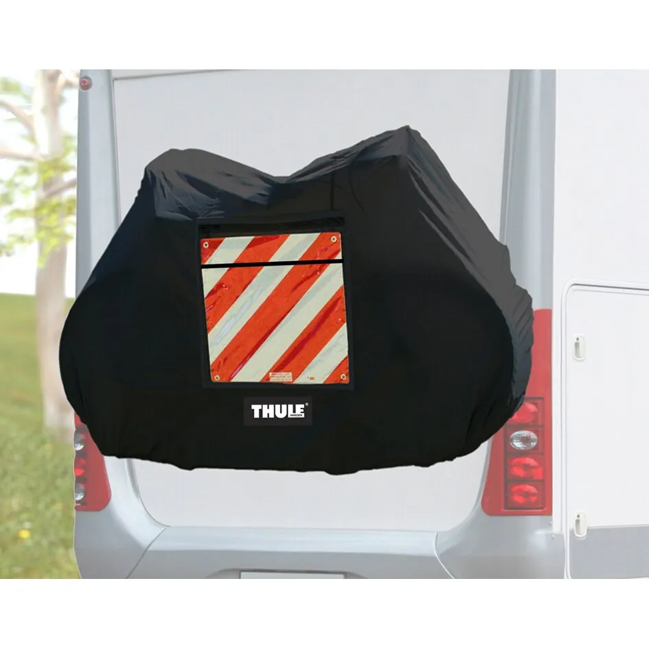 Schwarze Thule-Fahrradschutzhülle für drei Fahrräder am Heck eines Fahrzeugs mit rot-weißer Warntafel