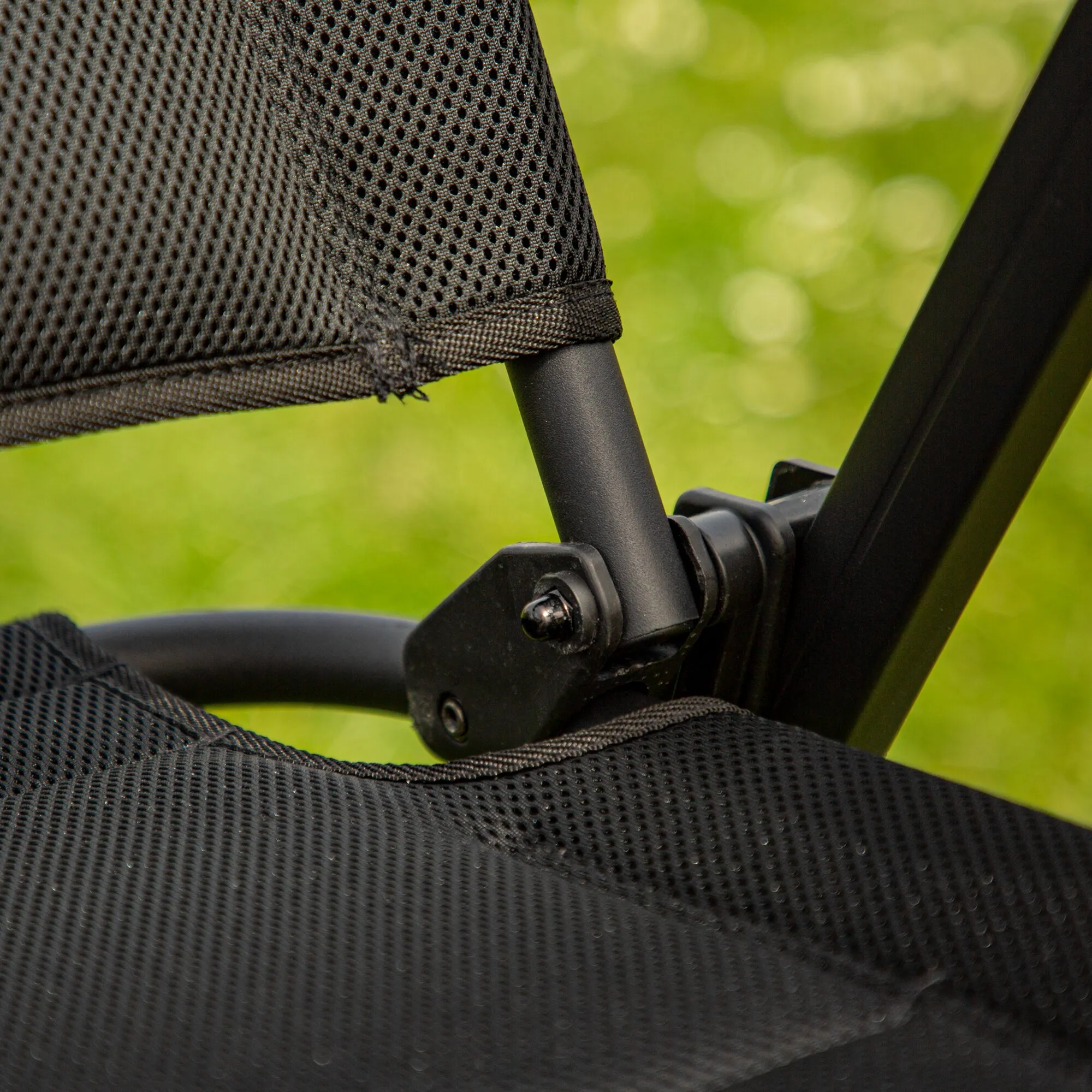 Detailaufnahme des schwarzen Campingstuhls Skye 3D mit atmungsaktivem Netzgewebe, Rahmen und verstellbarem Gelenk vor grünem Hintergrund