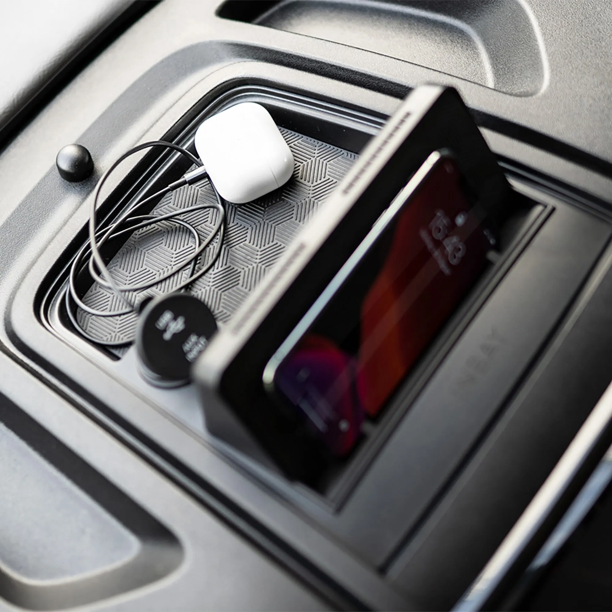 INBAY Qi-Ladestation im Ablagefach eines Fiat Ducato mit aufgelegtem Smartphone und angeschlossenem Ladekabel