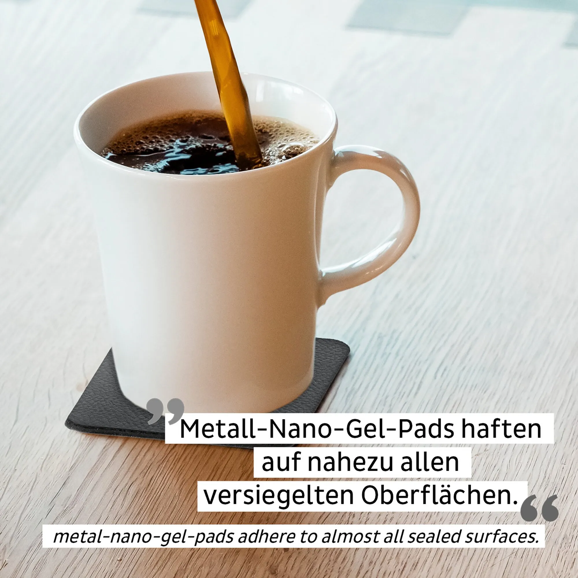 Weiße Porzellantasse mit Henkel und Kaffee auf schwarzem Haftpad; Kaffee wird eingegossen, Hinweis auf Metall-Nano-Gel-Pads sichtbar