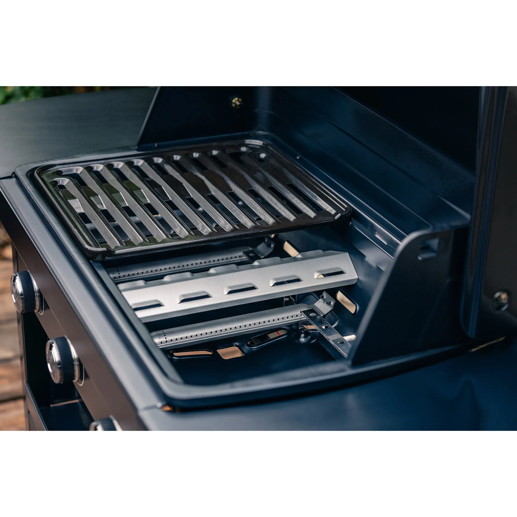 Innenansicht des geöffneten Gasgrills Compact 3 L mit verchromtem Grillrost, drei Brennern und Flammschutzblechen