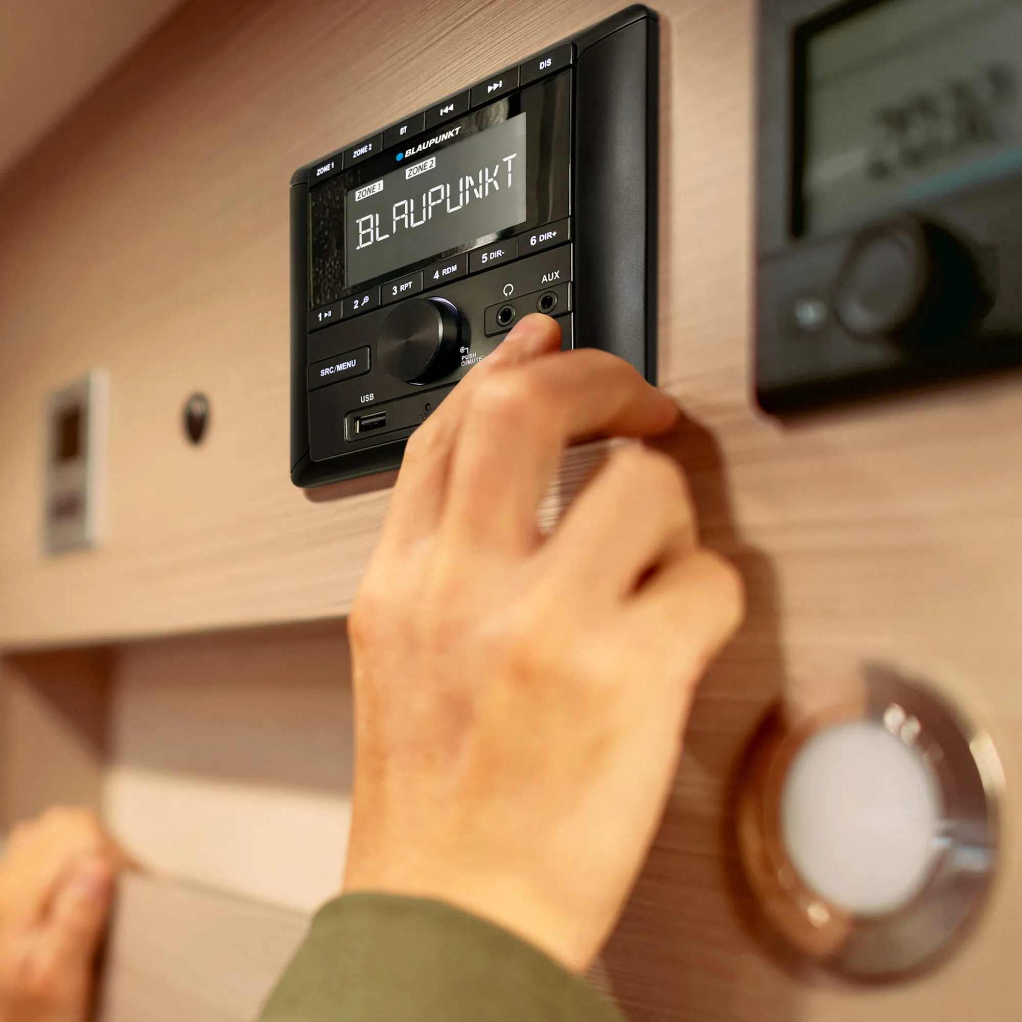 Schwarzes Einbauradio Blaupunkt Camper BPA 3022 M mit Display, USB- und AUX-Anschlüssen, von einer Hand bedient