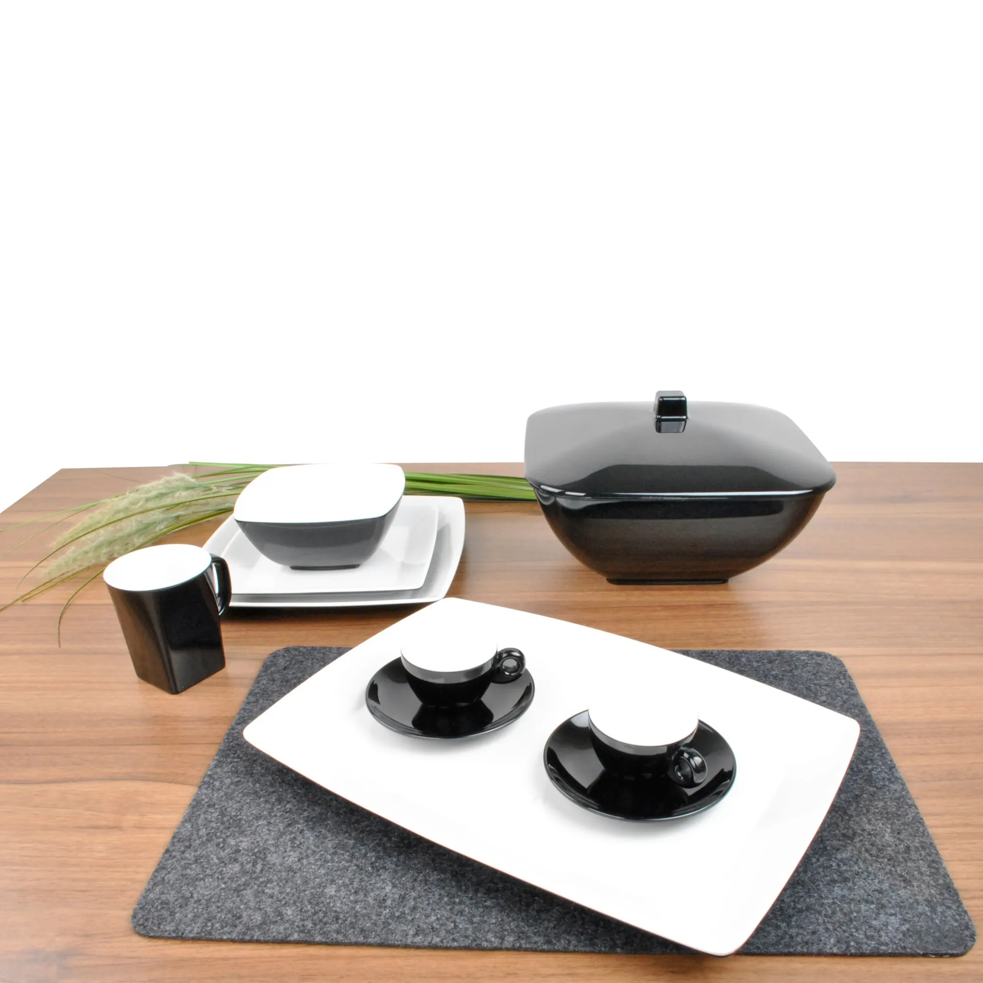 Schwarzes Espressoset Solid Line mit zwei Tassen und Untertassen, weiterer Tasse und Schale auf einem Holztisch