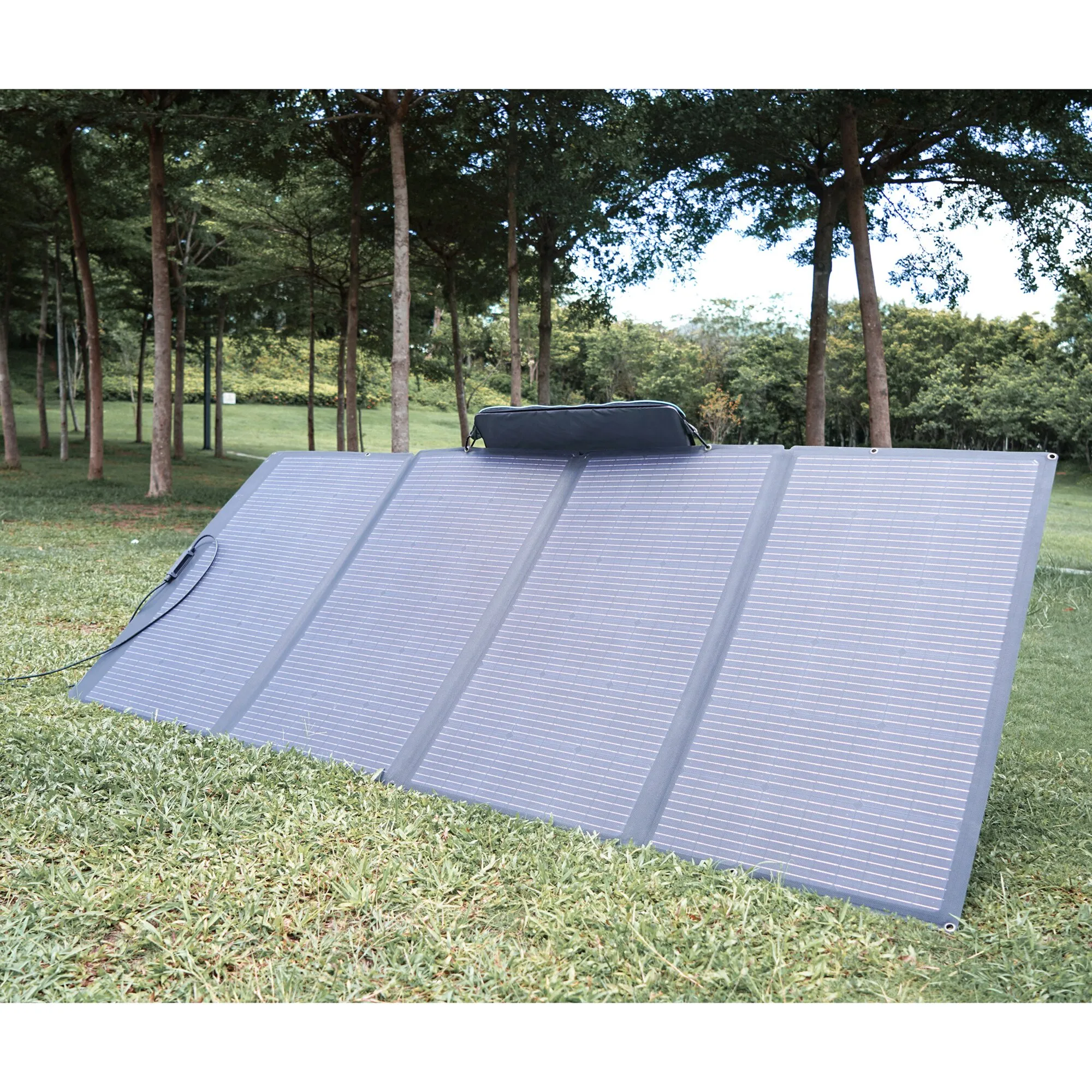 Auf einer Wiese ausgeklapptes faltbares Solarmodul mit mehreren Solarflächen, Anschlusskabel und Tragetasche, 400 Wp