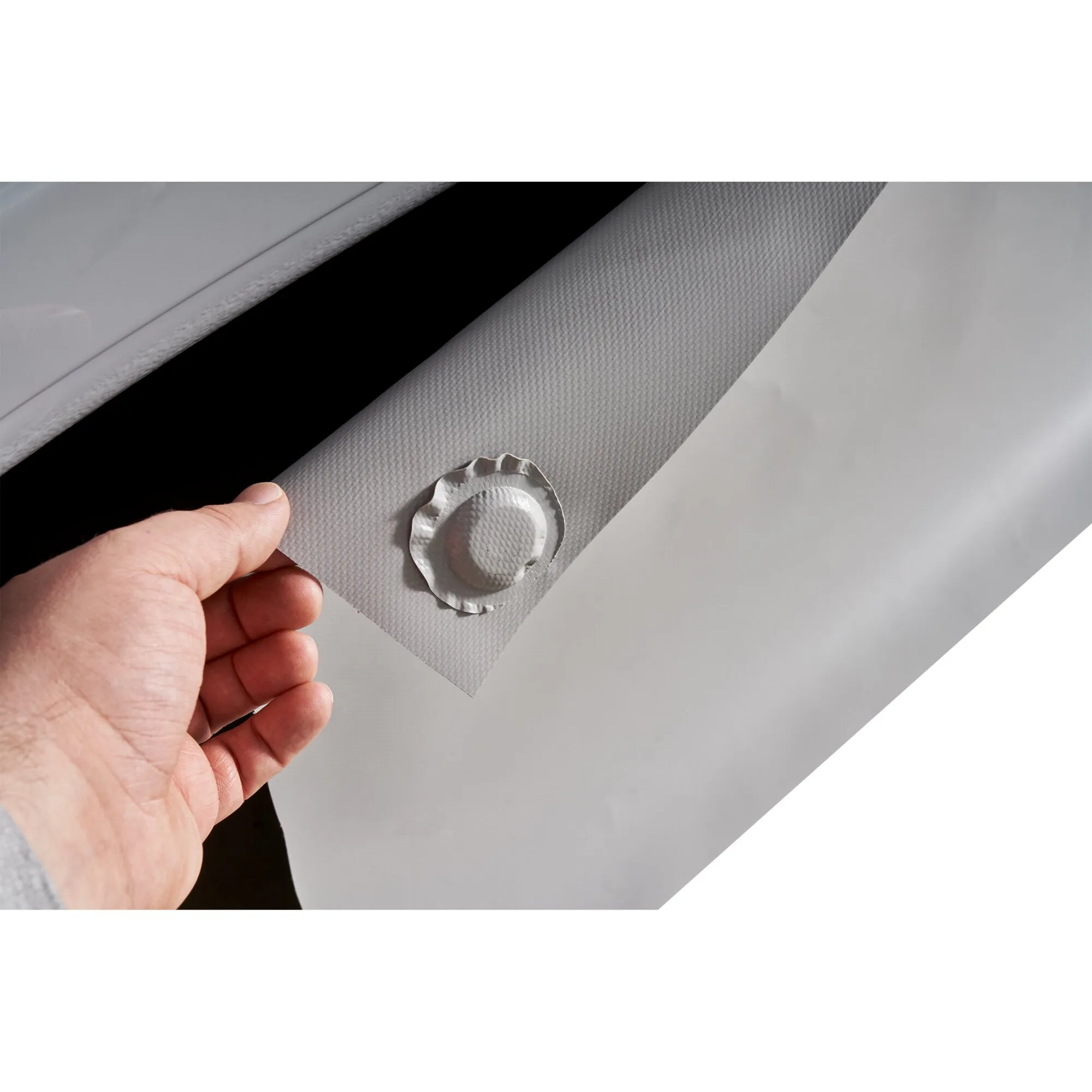 Graue Magnet-Windblende für den Ducato mit rundem Magneten, von einer Hand an einer Fahrzeugöffnung gehalten
