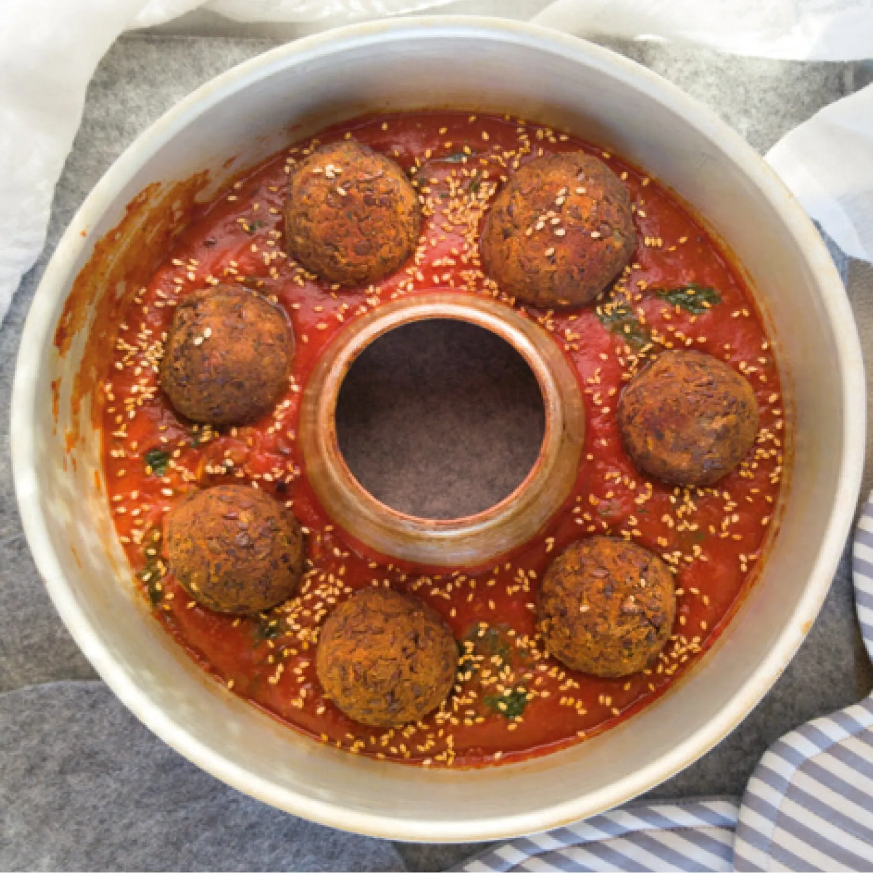 Gebackene Bällchen in würziger Tomatensoße mit Sesam und Kräutern im Omnia-Backofen aus dem Kochbuch Leicht & Fit Rezepte
