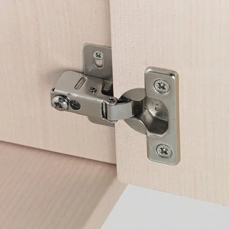 Silbernes Schrankscharnier aus Metall an einer hellen Schranktür, Detailansicht mit sichtbaren Kreuzschlitzschrauben