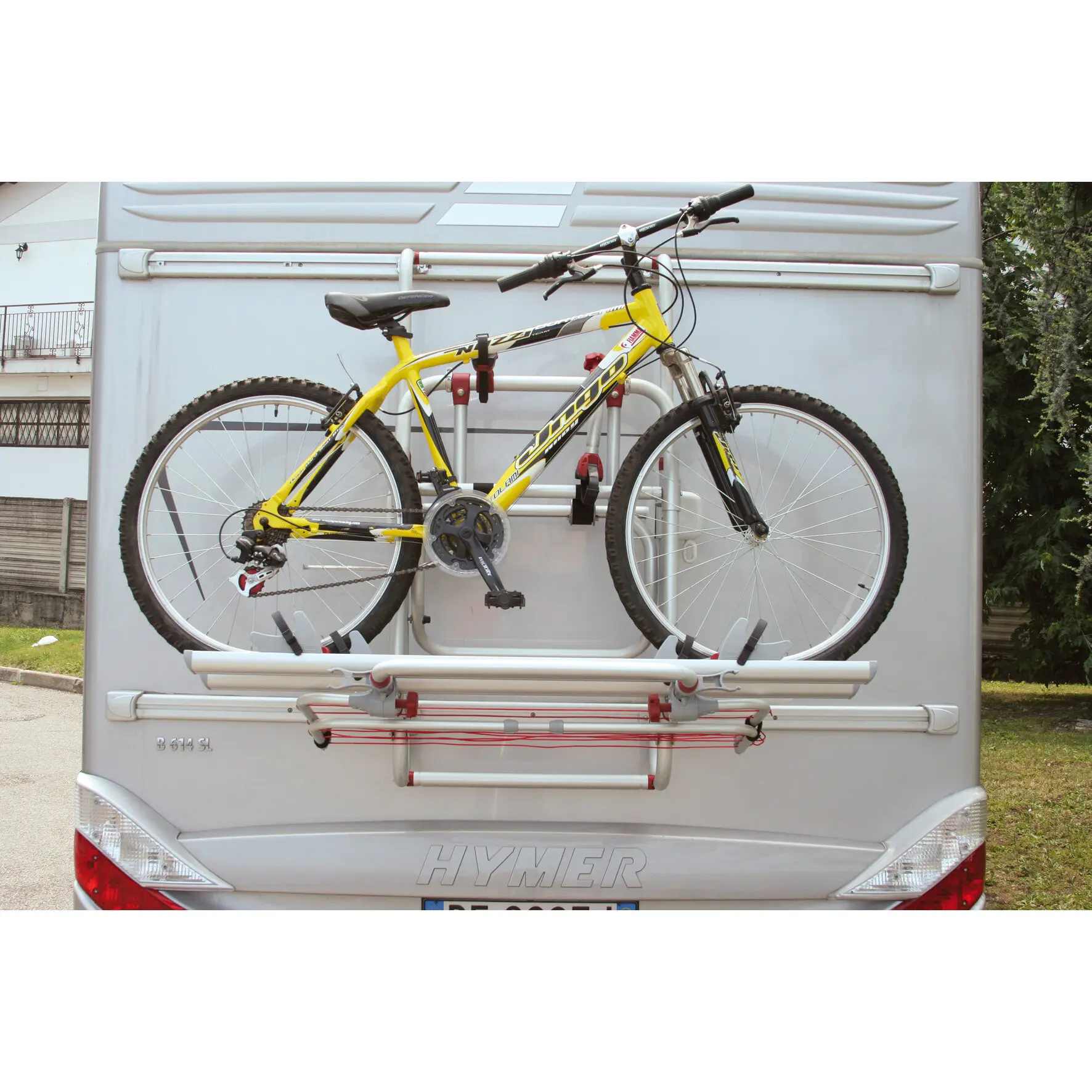 Rückseite eines silbernen Hymer-Wohnmobils mit Fahrradheckträger, auf dem ein gelbes Mountainbike mit schwarzem Rahmen montiert ist